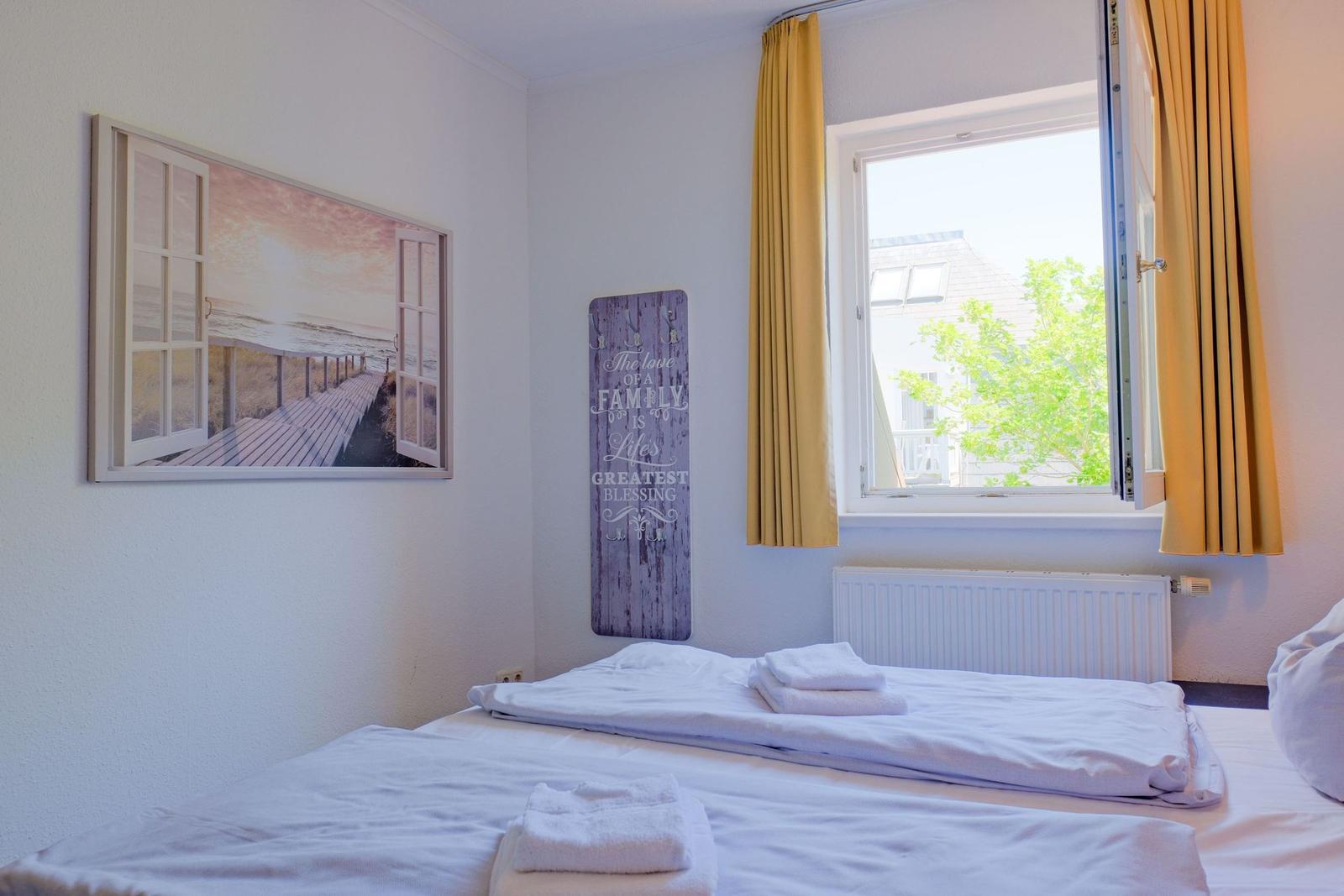 Schlafzimmer mit Bett, Fenster und Wandbild