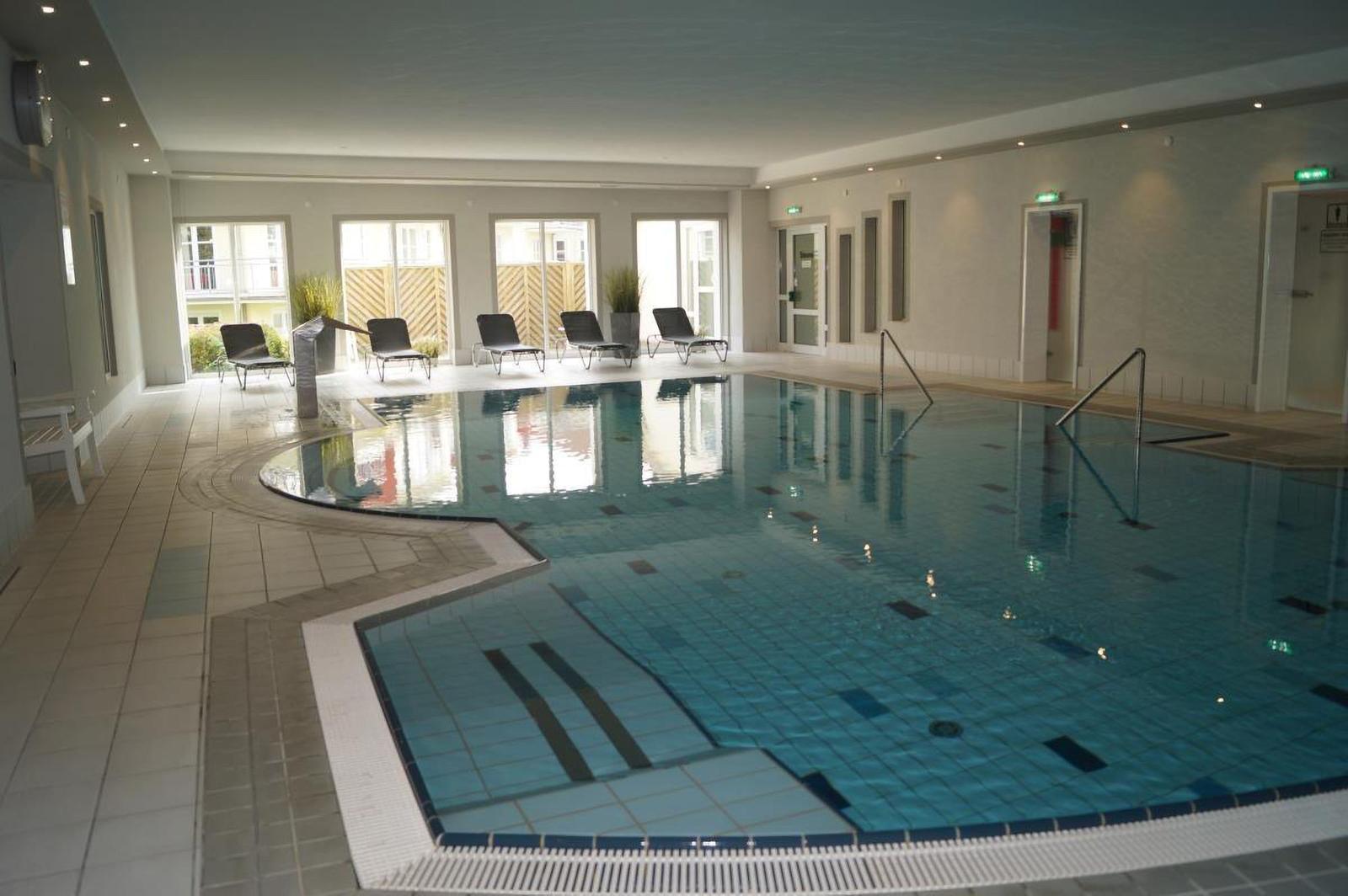 Innenpool mit Liegestühlen und Glasfronten
