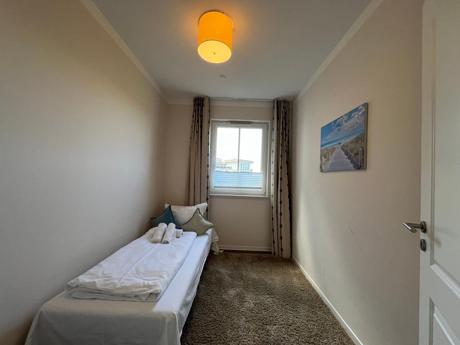 Schlafzimmer mit Bett, Fenster und Wandbild