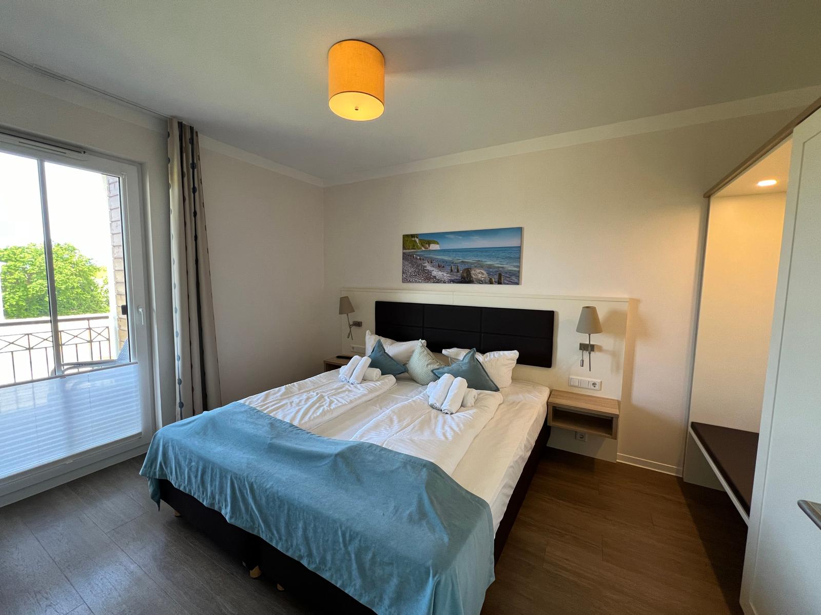 Schlafzimmer mit Doppelbett, Balkon und Wandbild