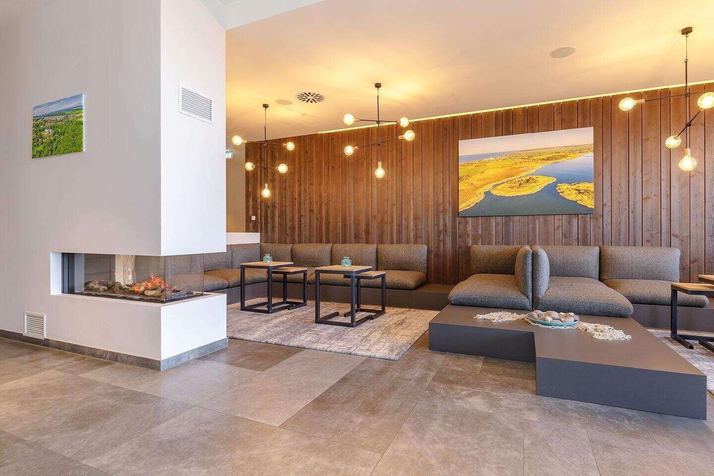 Wohnbereich mit Sofa, Kamin und Holzwand