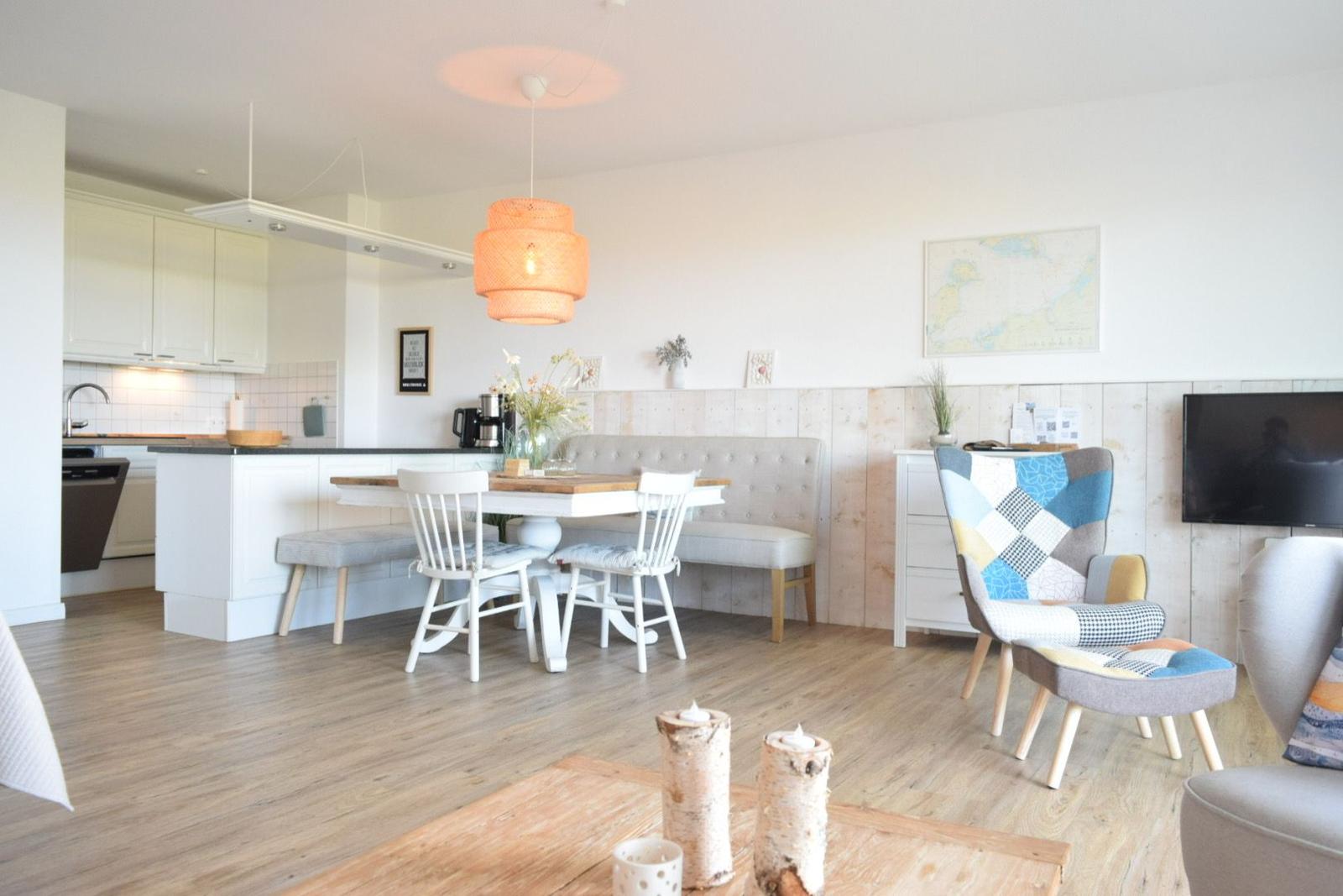 Küche, Essbereich und Wohnzimmer mit Holzboden und moderner Einrichtung.