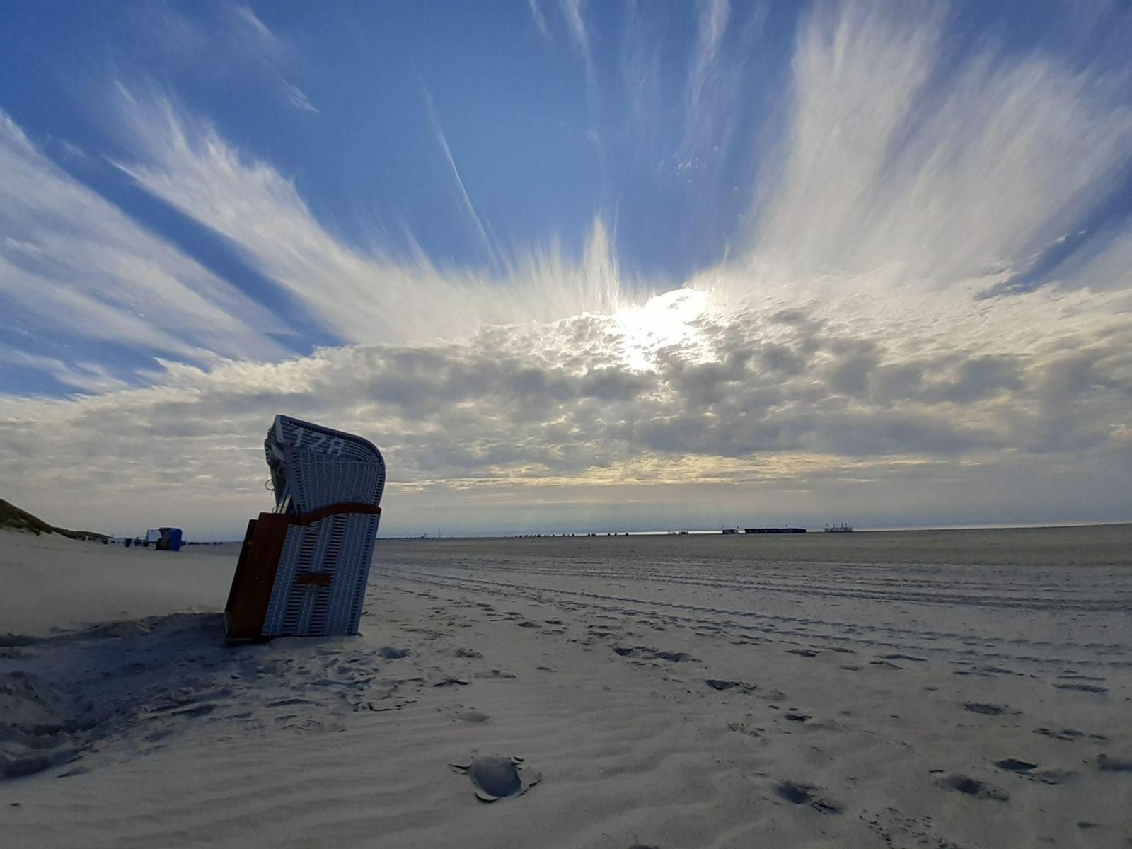 Strand mit Strandkorb und dramatischem Himmel