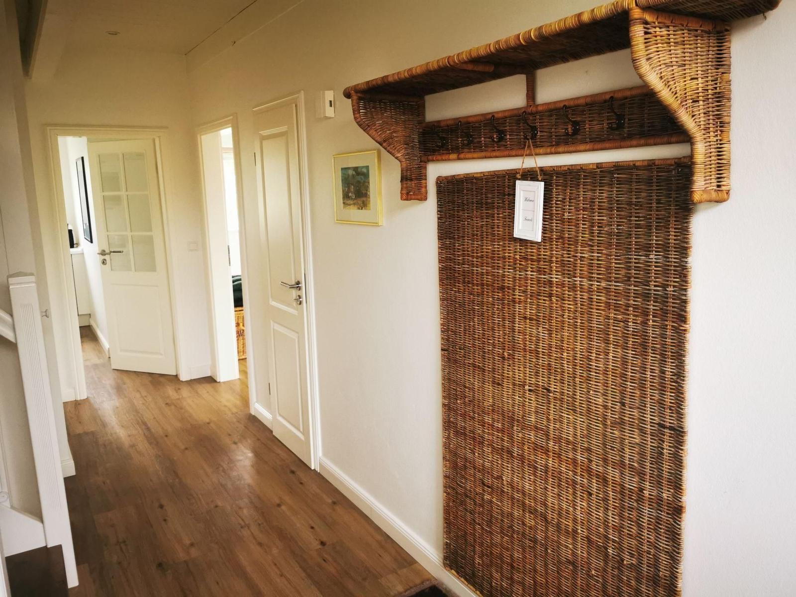 Flur mit Holzboden, Wicker-Wand und Haken