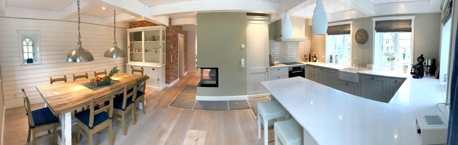 Küche mit Essbereich und Kamin im Hintergrund.