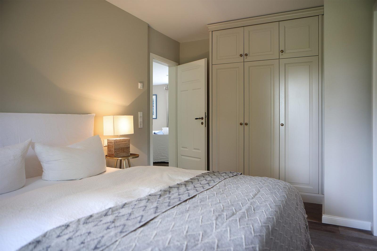 Schlafzimmer mit Bett, Nachttisch und Kleiderschrank.