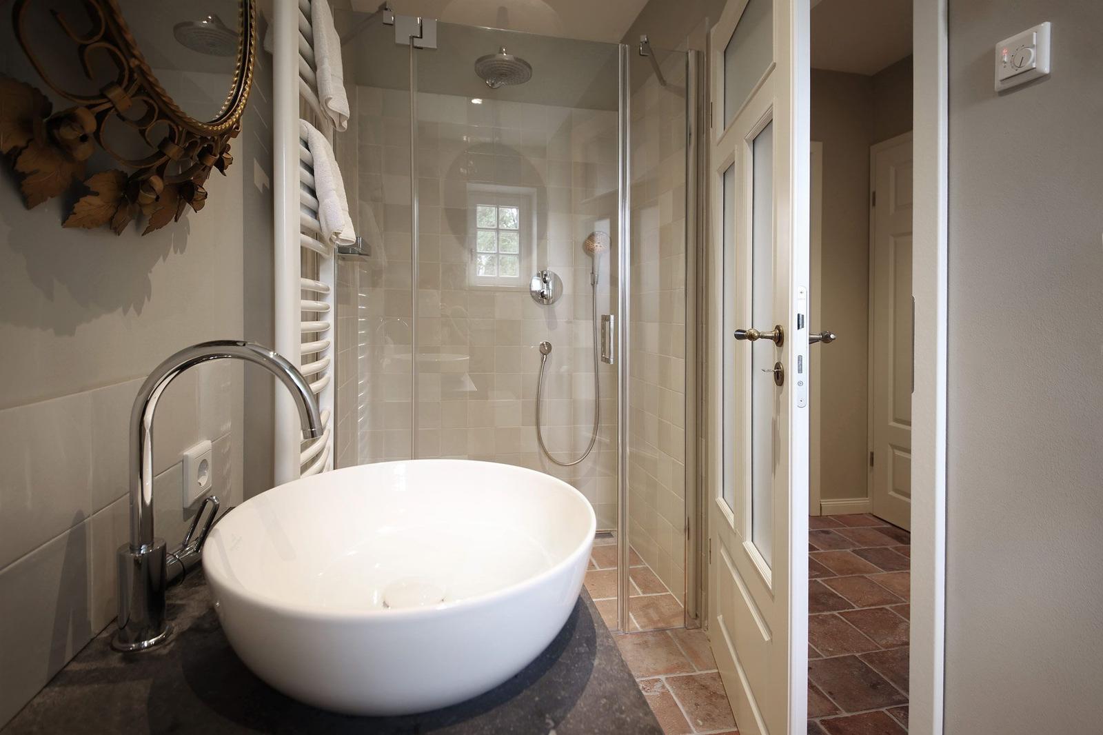 Bad mit freistehender Badewanne und Dusche mit Glaswand.