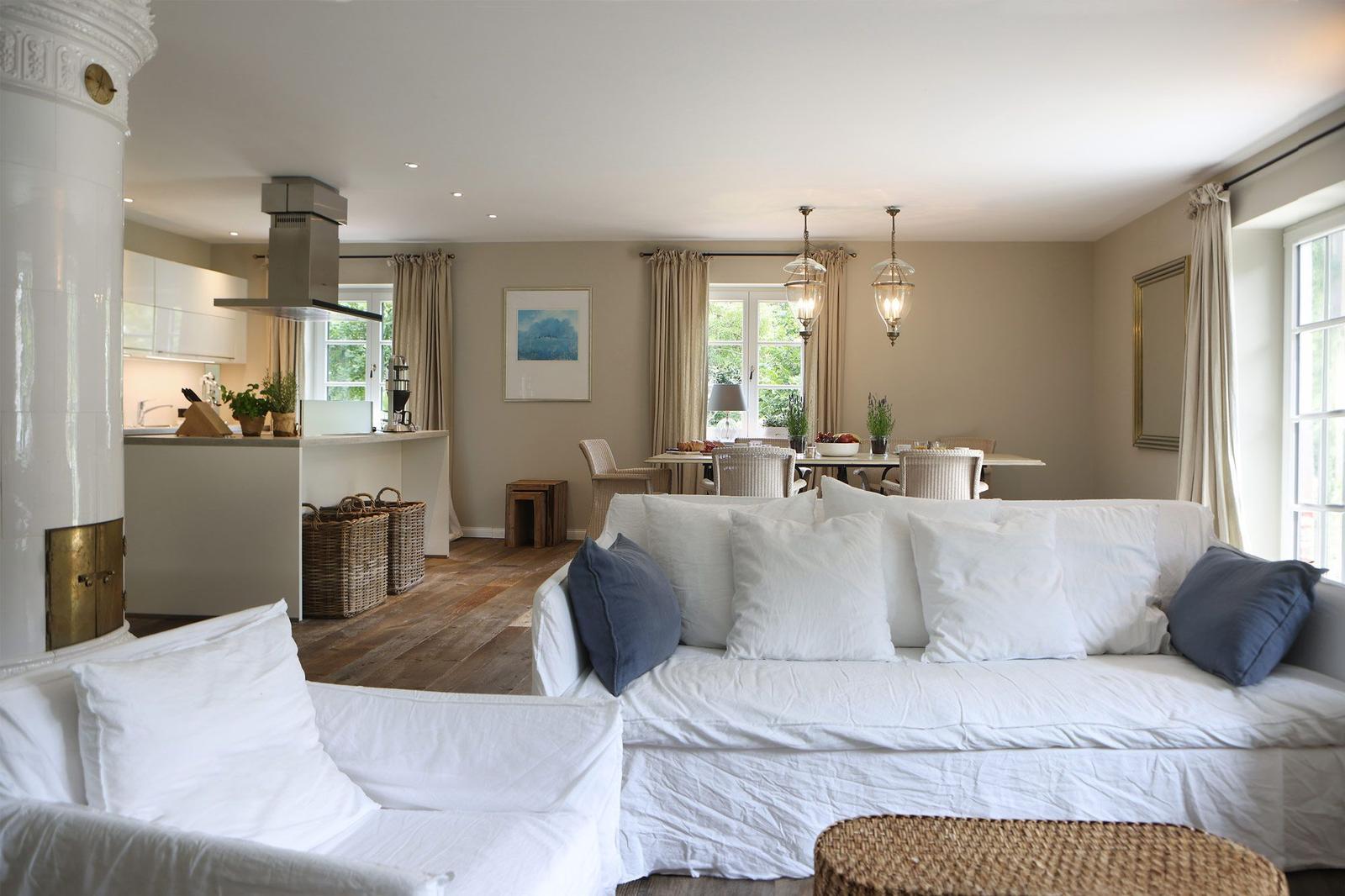 Wohn- und Essbereich mit Sofa, Tisch und Küche im Hintergrund.