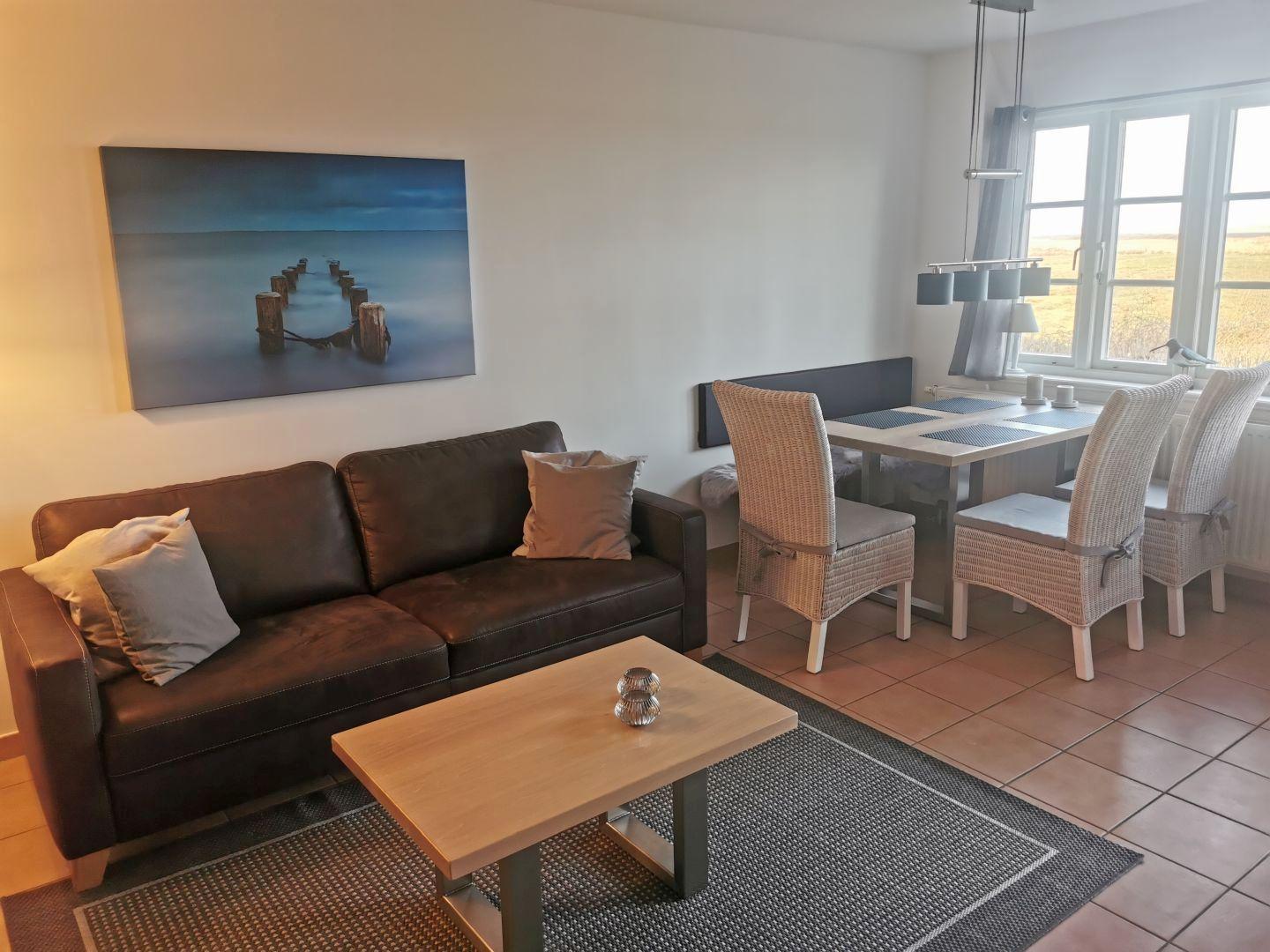 Wohn- und Essbereich mit Sofa, Esstisch und Fensterblick.