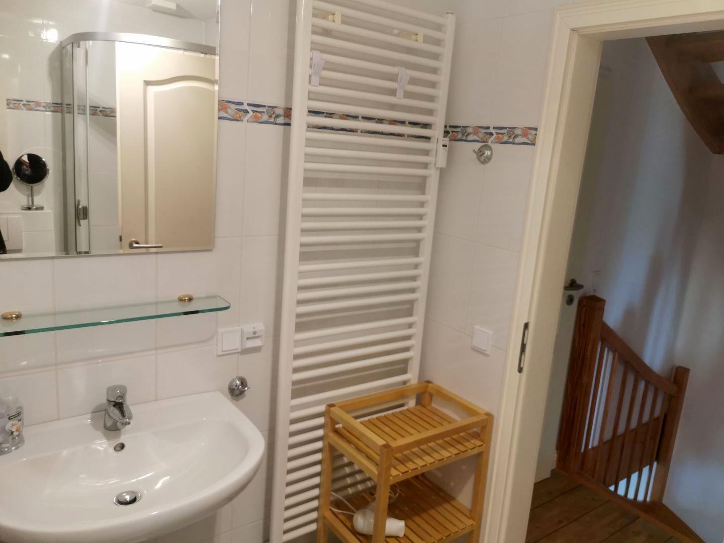 Badezimmer mit Waschbecken, Spiegel und Heizkörper