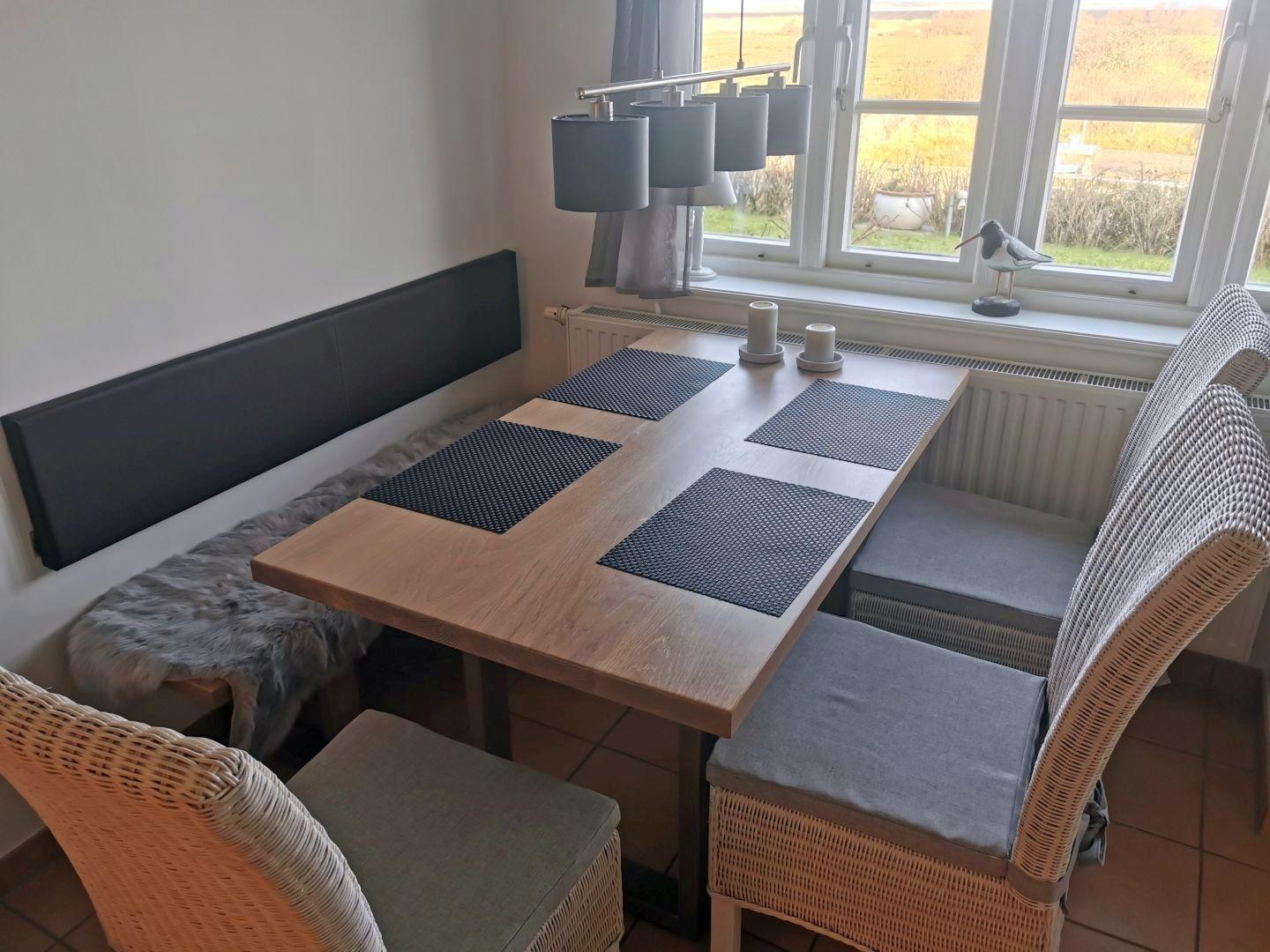 Esstisch mit Sitzgelegenheiten und Fensterblick.