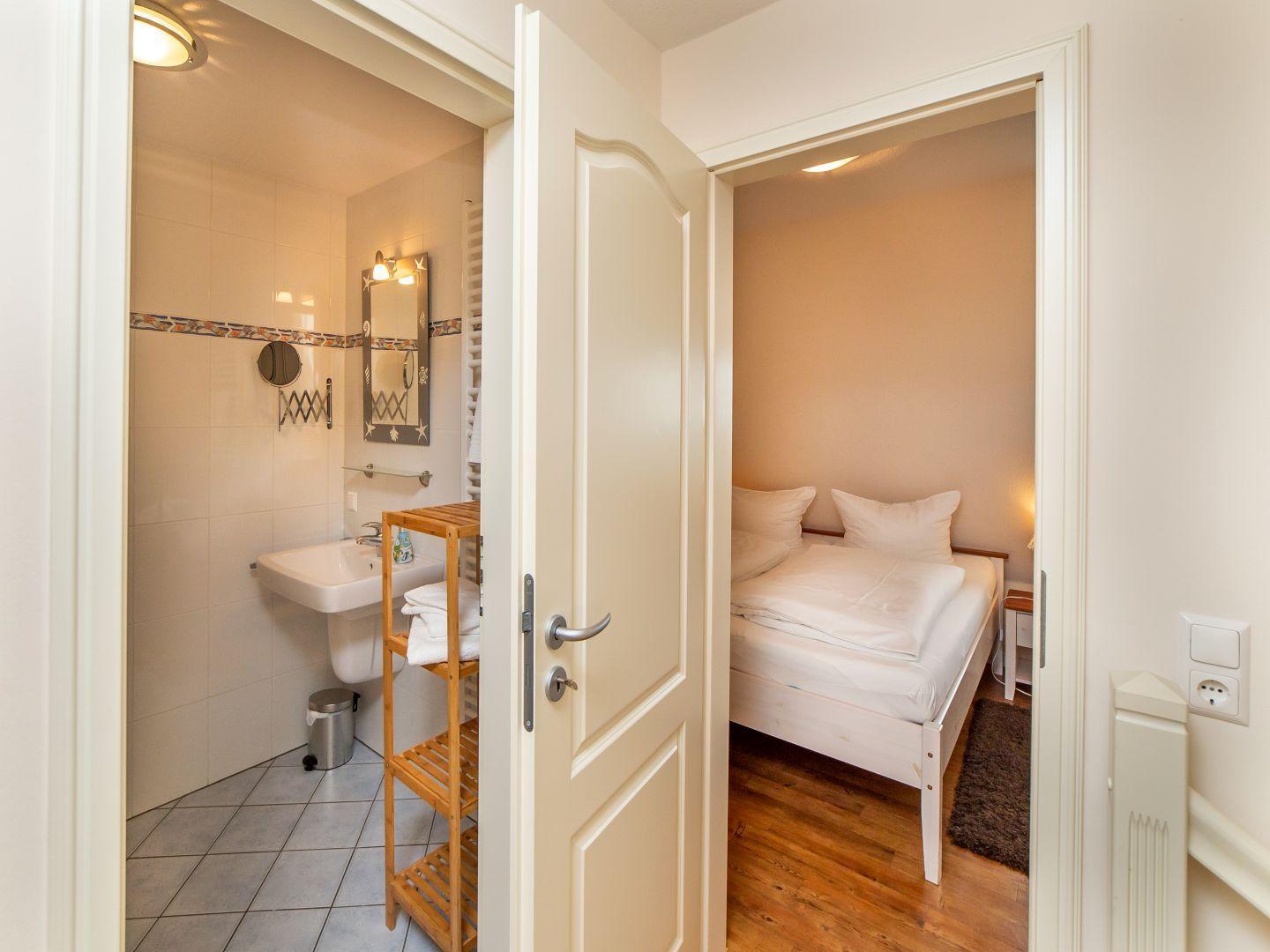 Zimmer mit Bett und angrenzender Badewanne mit Waschbecken.