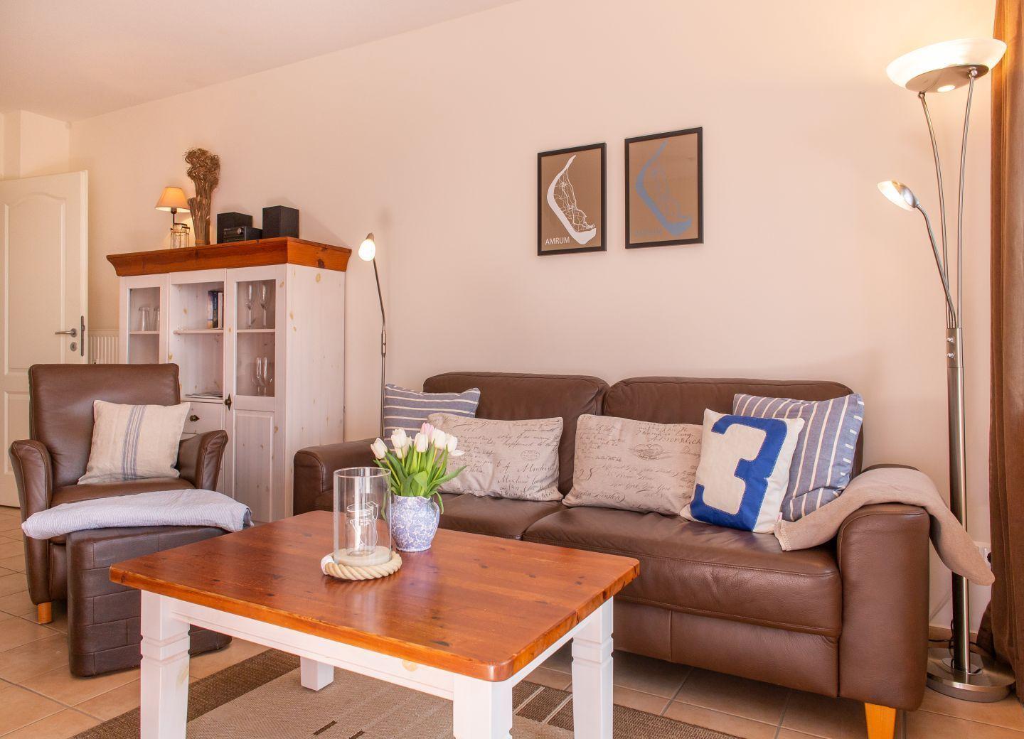 Wohnzimmer mit braunem Sofa, Holztisch und dekorativen Kissen.