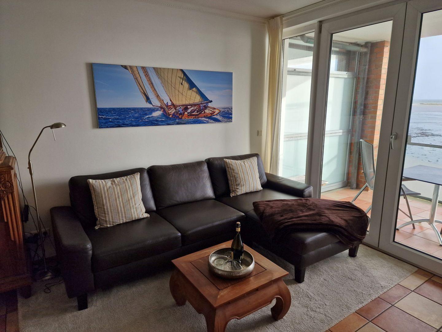 Wohnzimmer mit Sofa, Couchtisch und Blick auf die Terrasse.