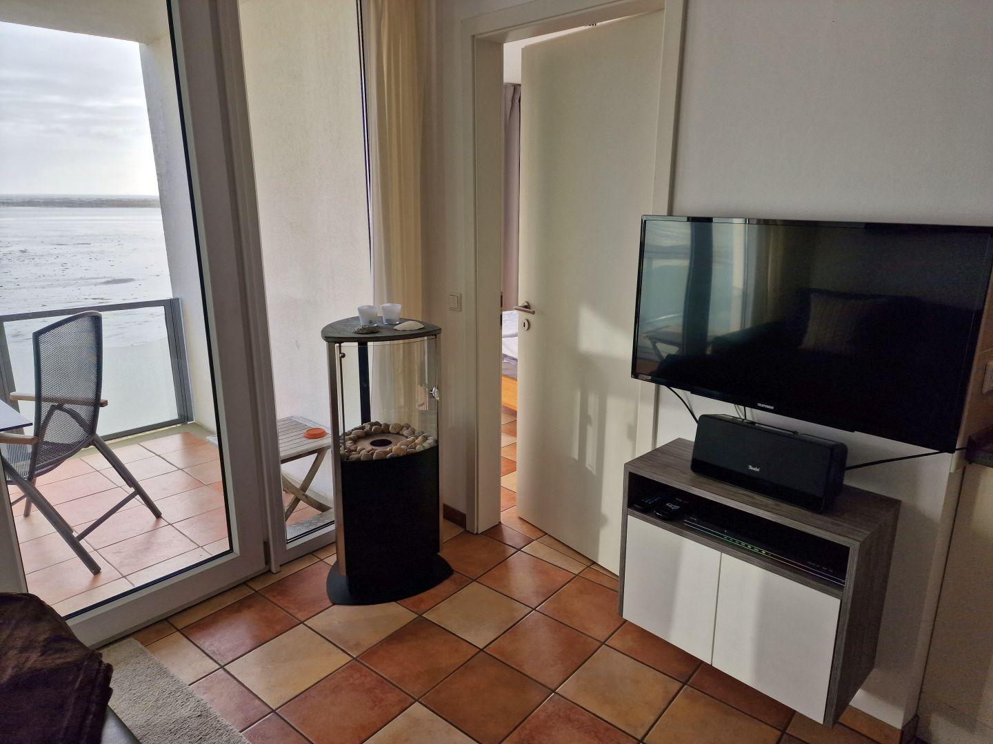 Wohnbereich mit TV, Terrasse und Meerblick.