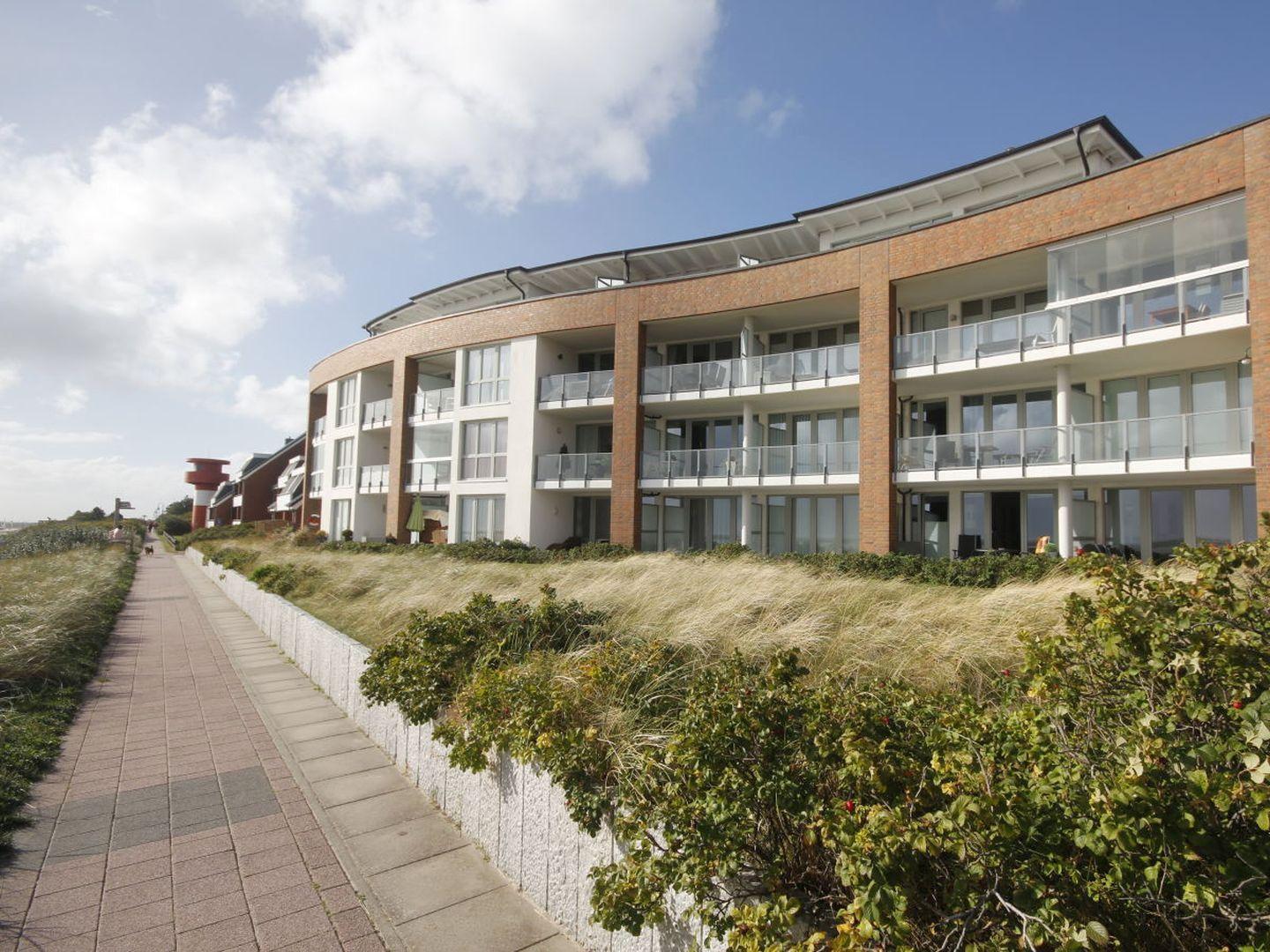 Modernes Mehrfamilienhaus mit Balkonen an der Strandpromenade.