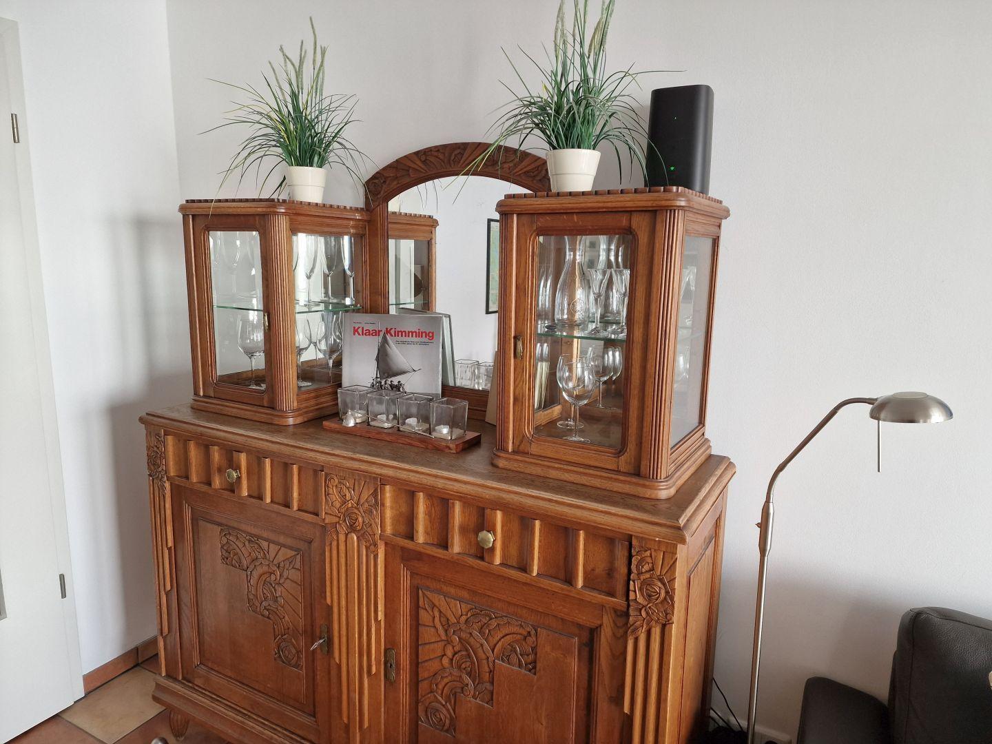Holzschrank mit Glaskästen, Pflanzen und Stehlampe