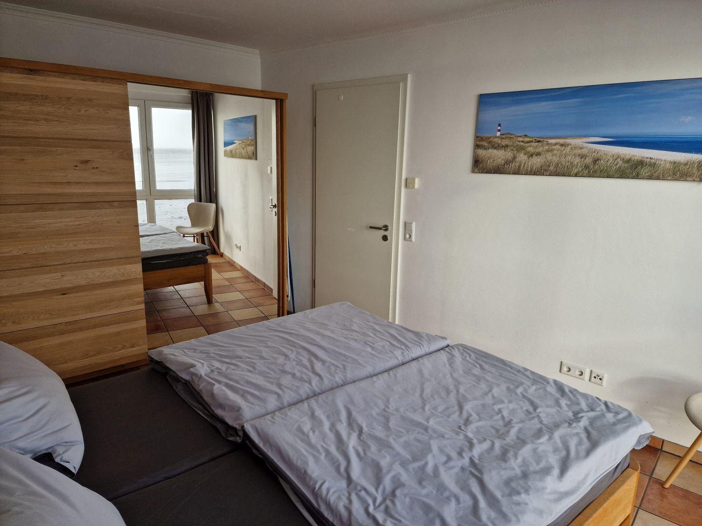 Schlafzimmer mit Bett und Blick aufs Meer