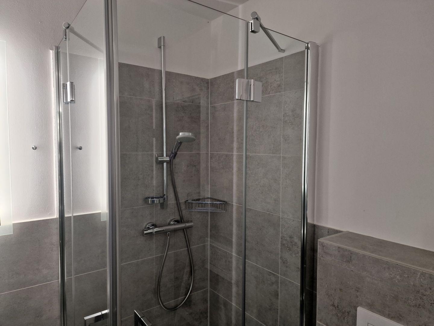 Dusche mit Glaswand und Duschbrause