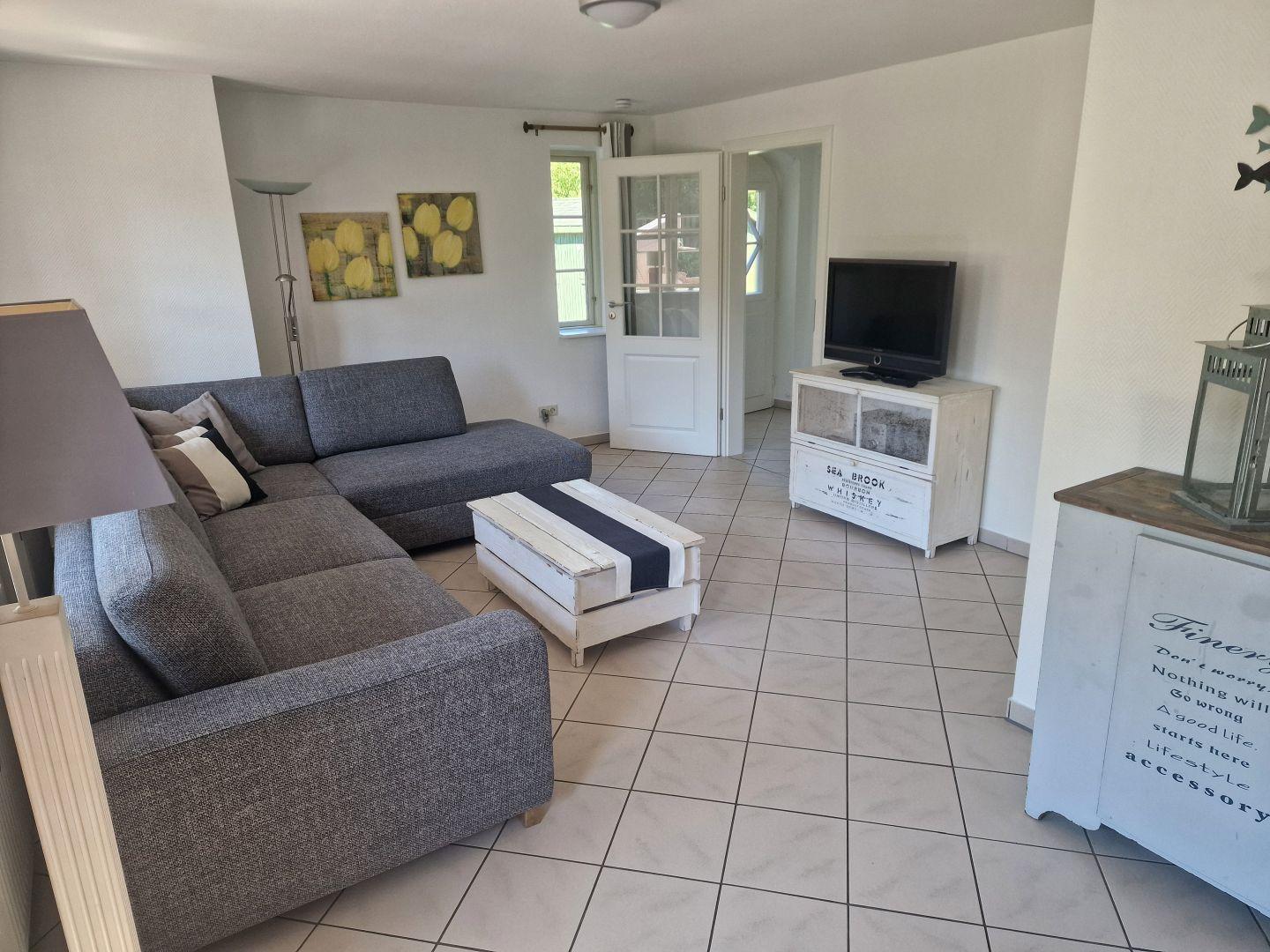 Wohnzimmer mit Sofa, Fernseher und Tisch