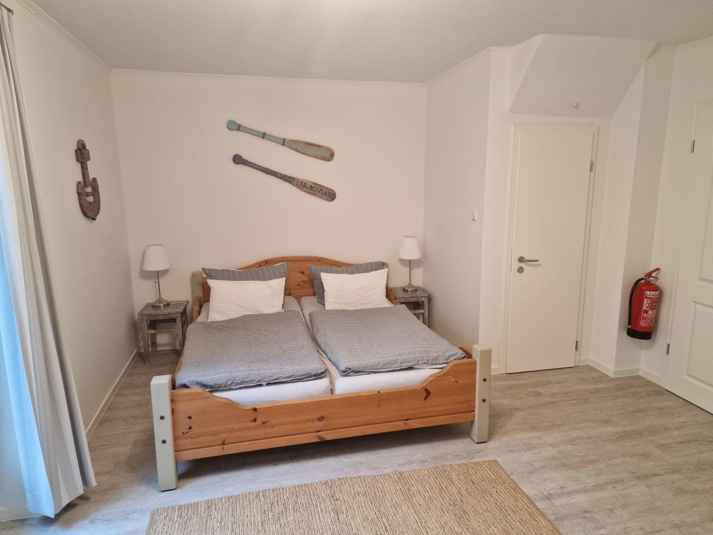 Schlafzimmer mit Doppelbett, zwei Nachttischen und Wanddekoration.