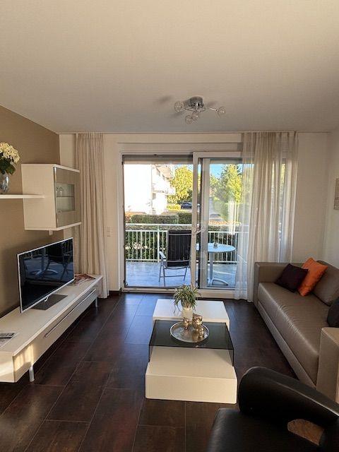 Living room with sofa, TV, and balcony view.