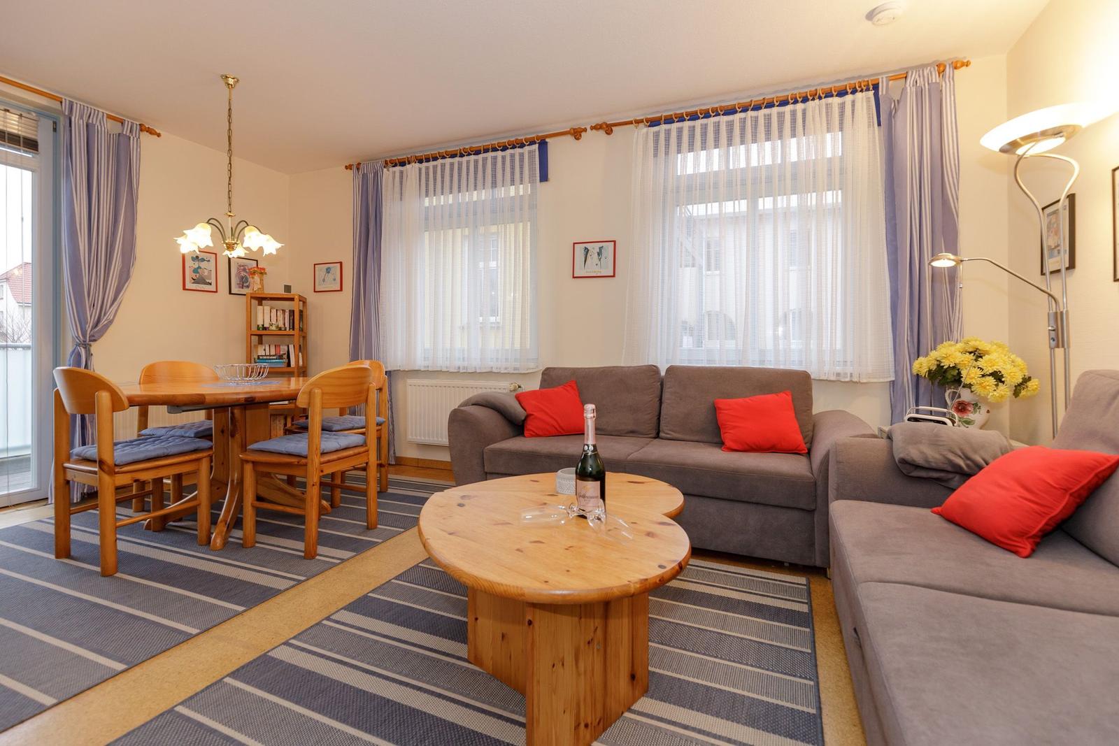 Wohn- und Essbereich mit Sofa, Tisch und Stühlen.