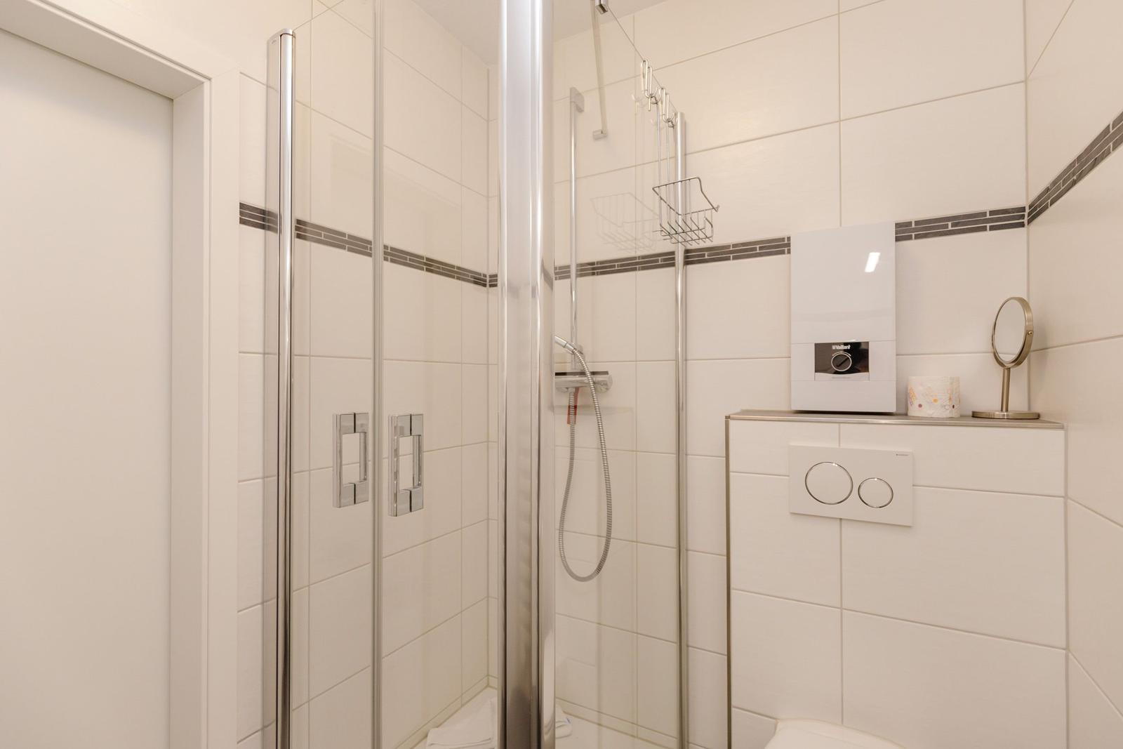 Dusche mit Glaswand, Toilette und Spiegelschrank