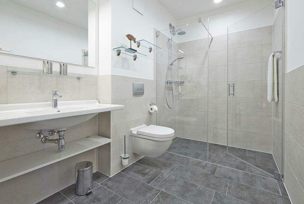 Badezimmer mit Dusche, Waschbecken und Toilette