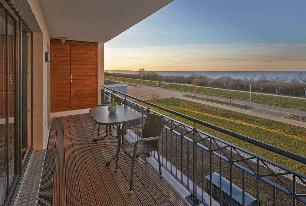 Terrasse mit Tisch und Stühlen bietet Meerblick.