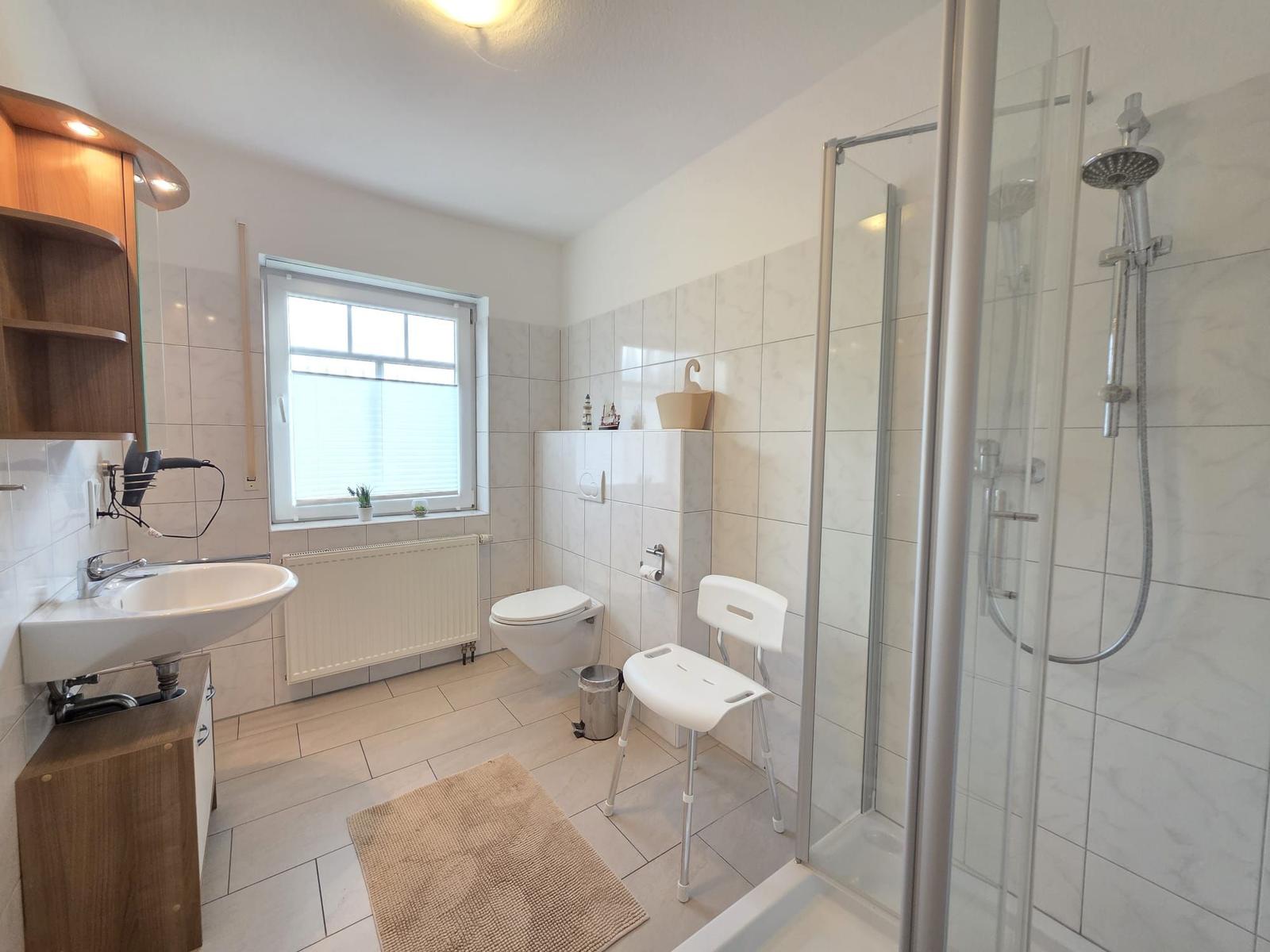 Badezimmer mit Dusche, Toilette und Waschbecken.