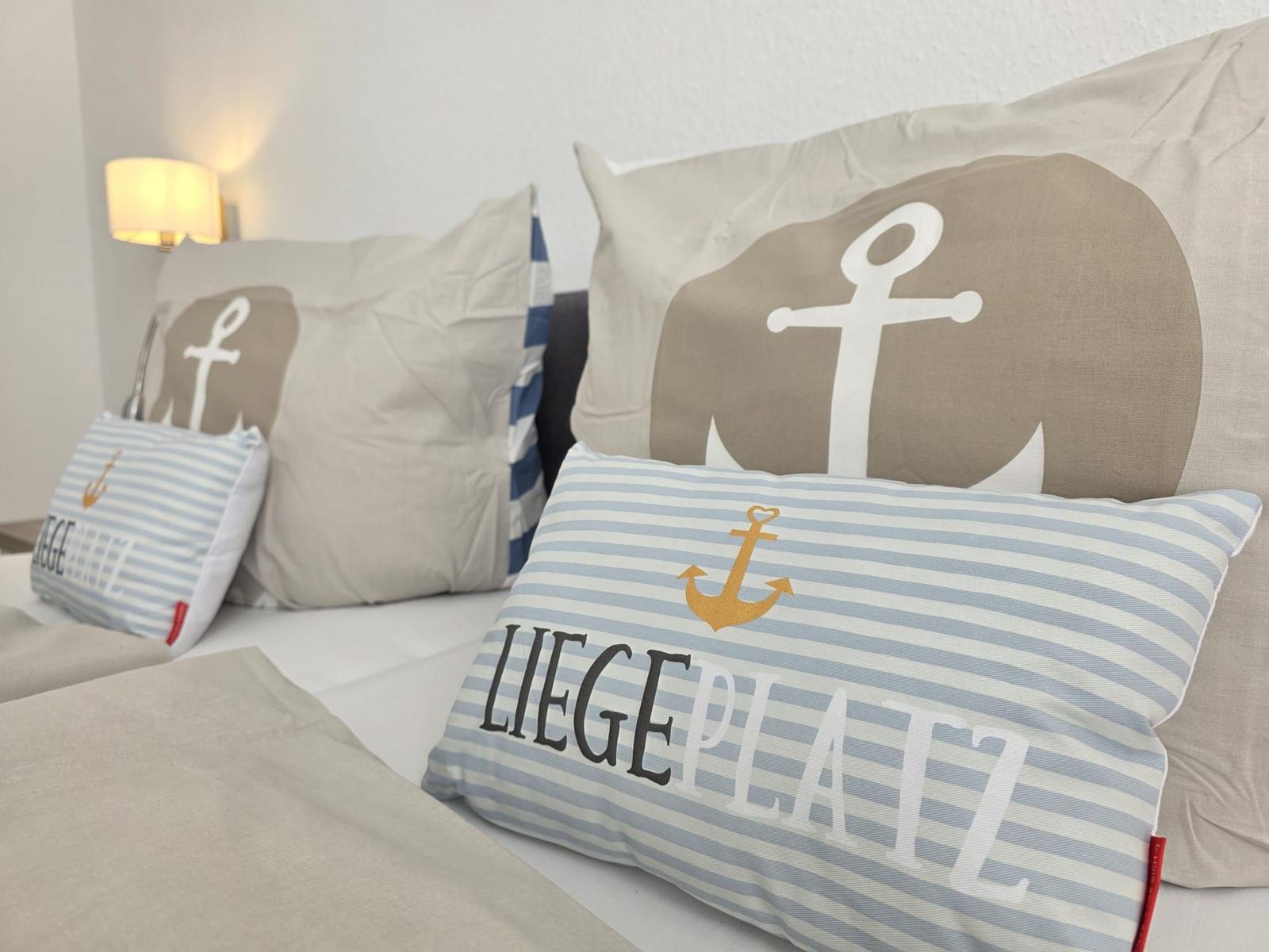 Bettkopfteil mit Kissen in Marineoptik und Wandlampe