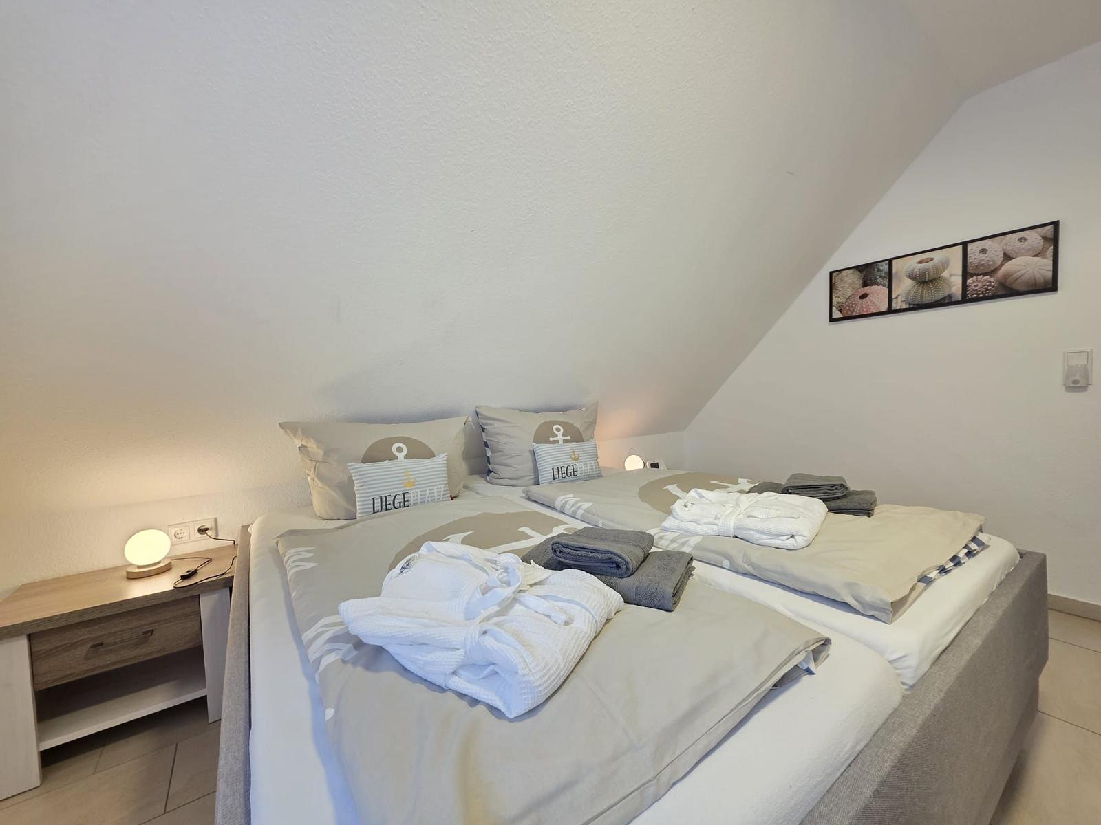 Bedroom with double bed, nightstand, and wall pictures