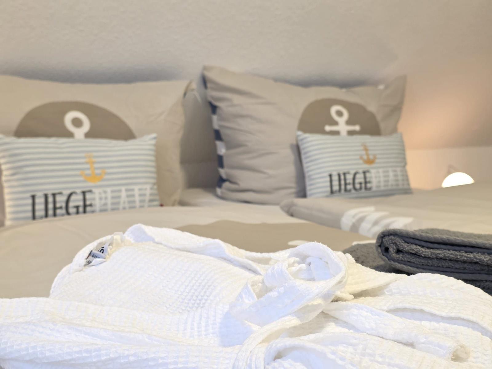 Bed head with pillows, with robe and towel below.