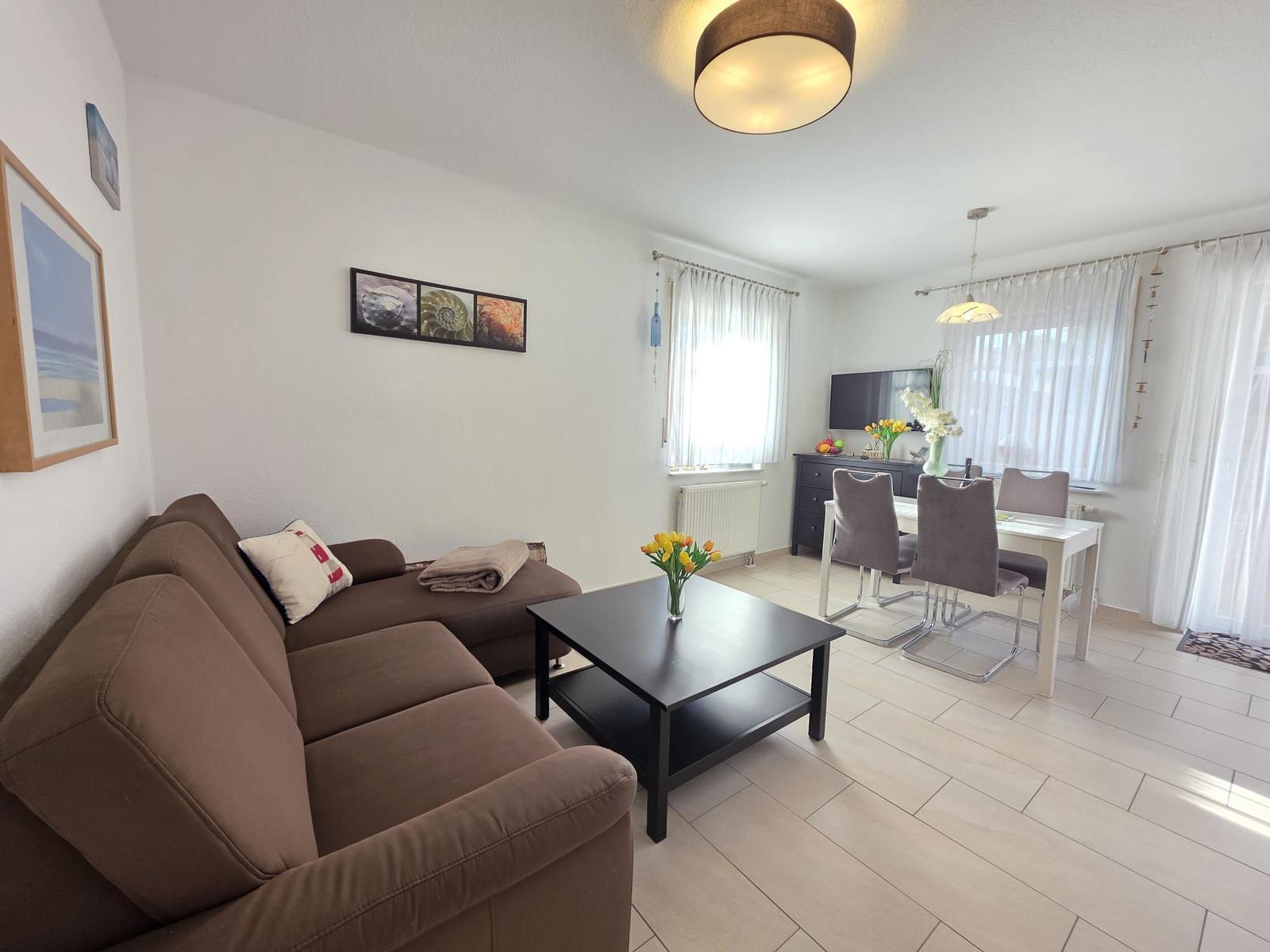 Living and dining area with sofa, table, and chairs.