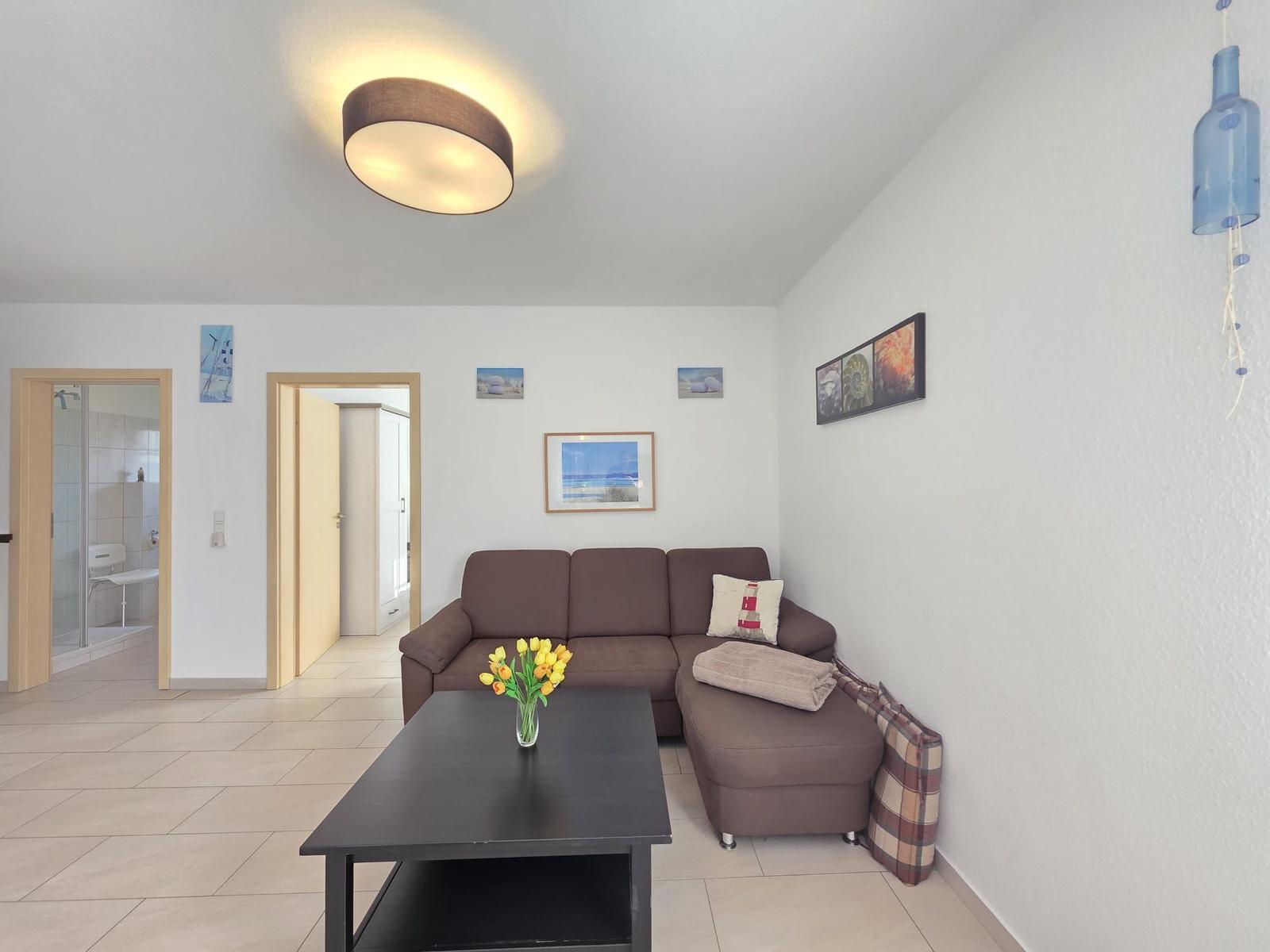 Living room with sofa, table, and pictures on the wall.