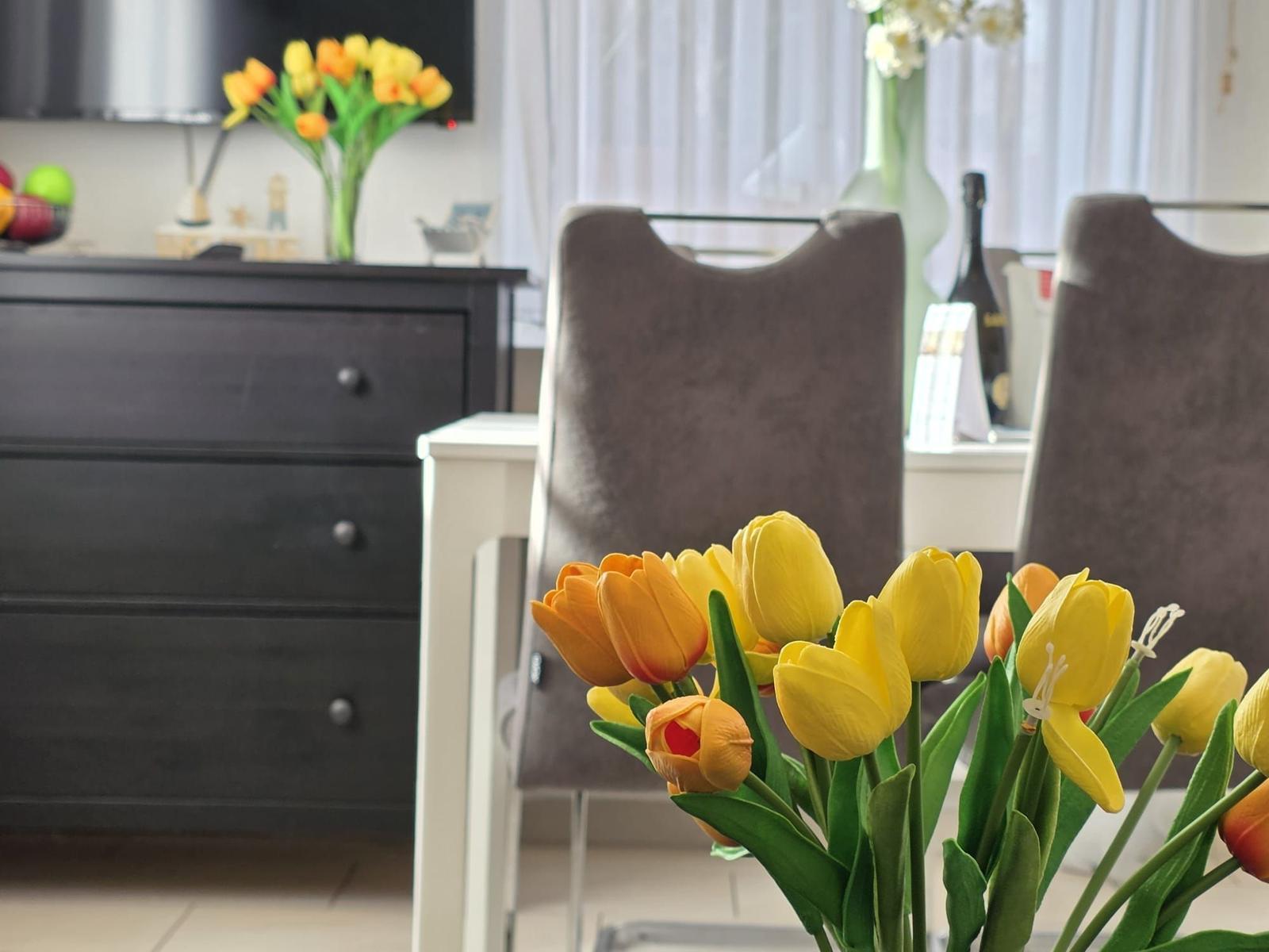 Table with chairs and tulip flowers in dining area