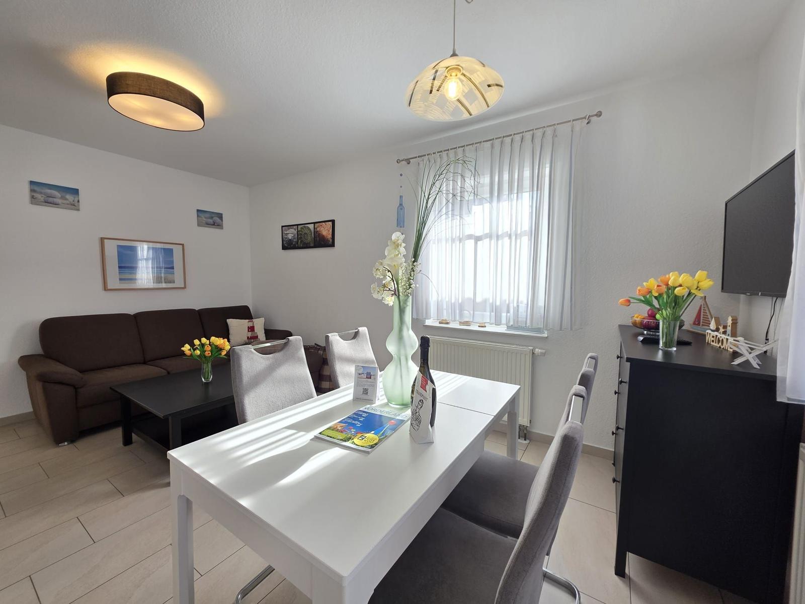 Living and dining area with sofa, dining table, and TV.