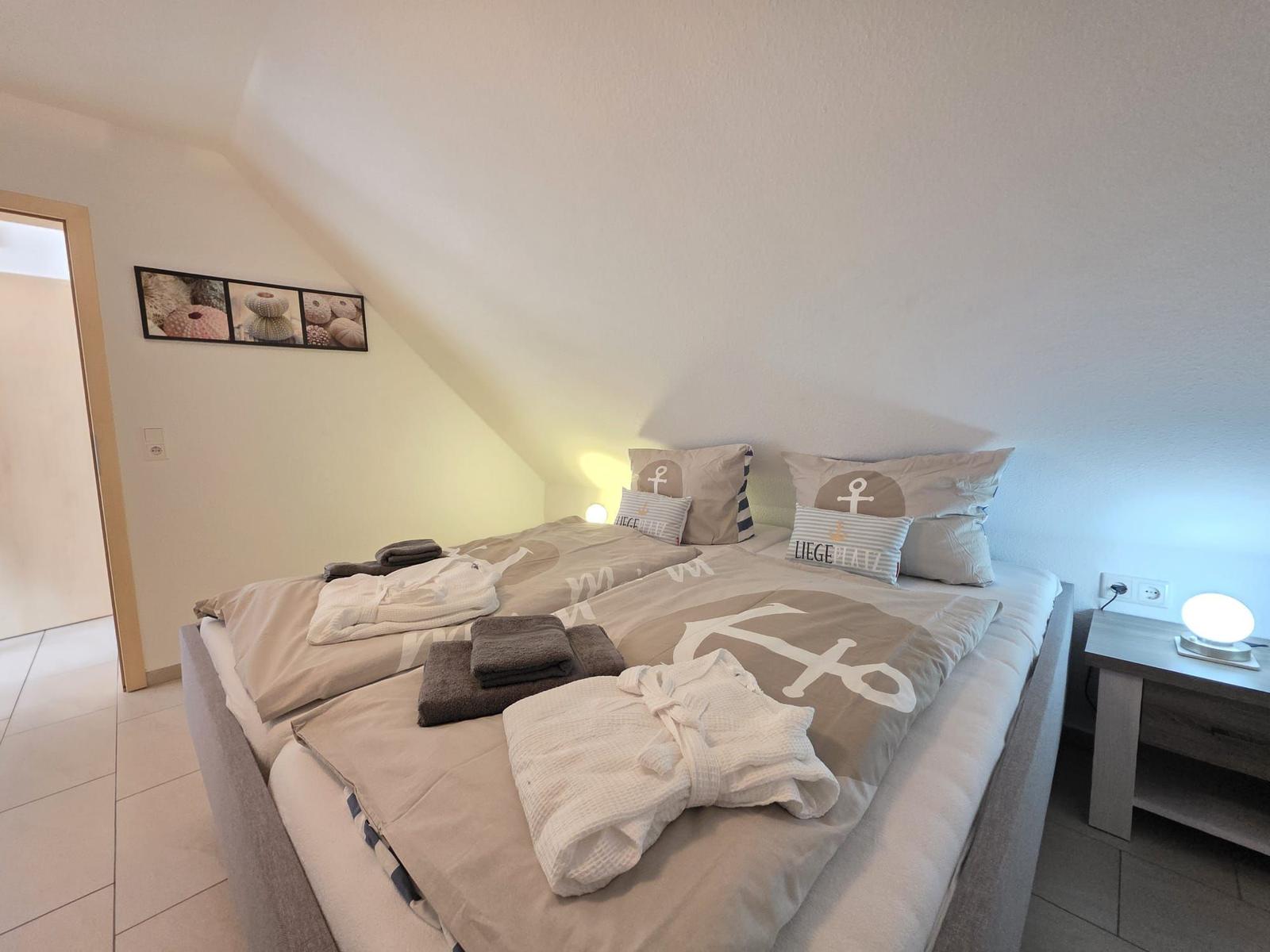 Bedroom with double bed, nightstand, and wall art