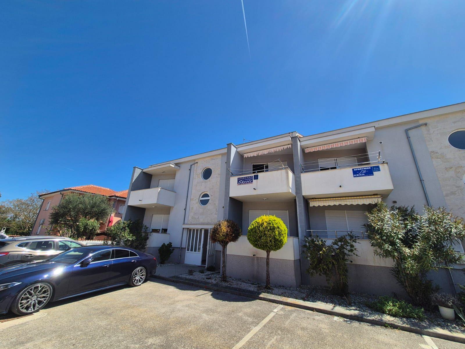 Moderne Wohnanlage mit Balkonen und gepflegtem Außenbereich unter blauem Himmel.