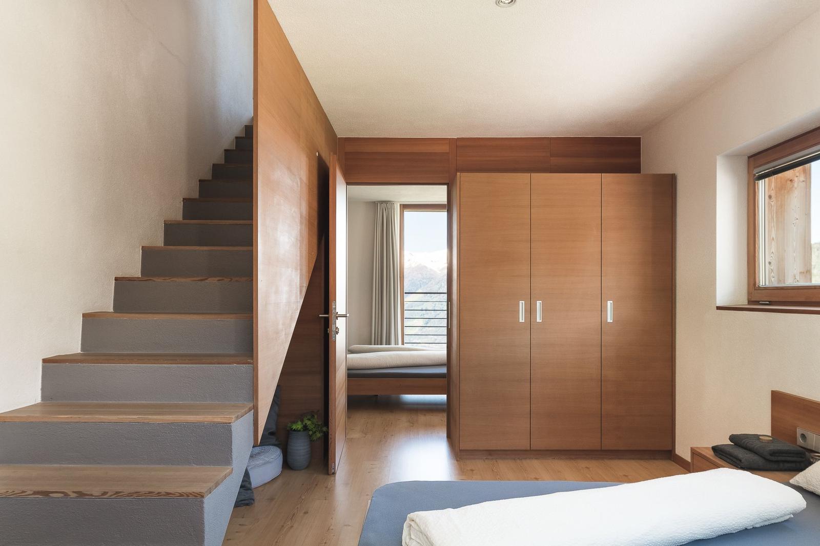 Schlafbereich mit Blick ins zweite Schlafzimmer und Aufgang zum Wohnbereich im 2. OG