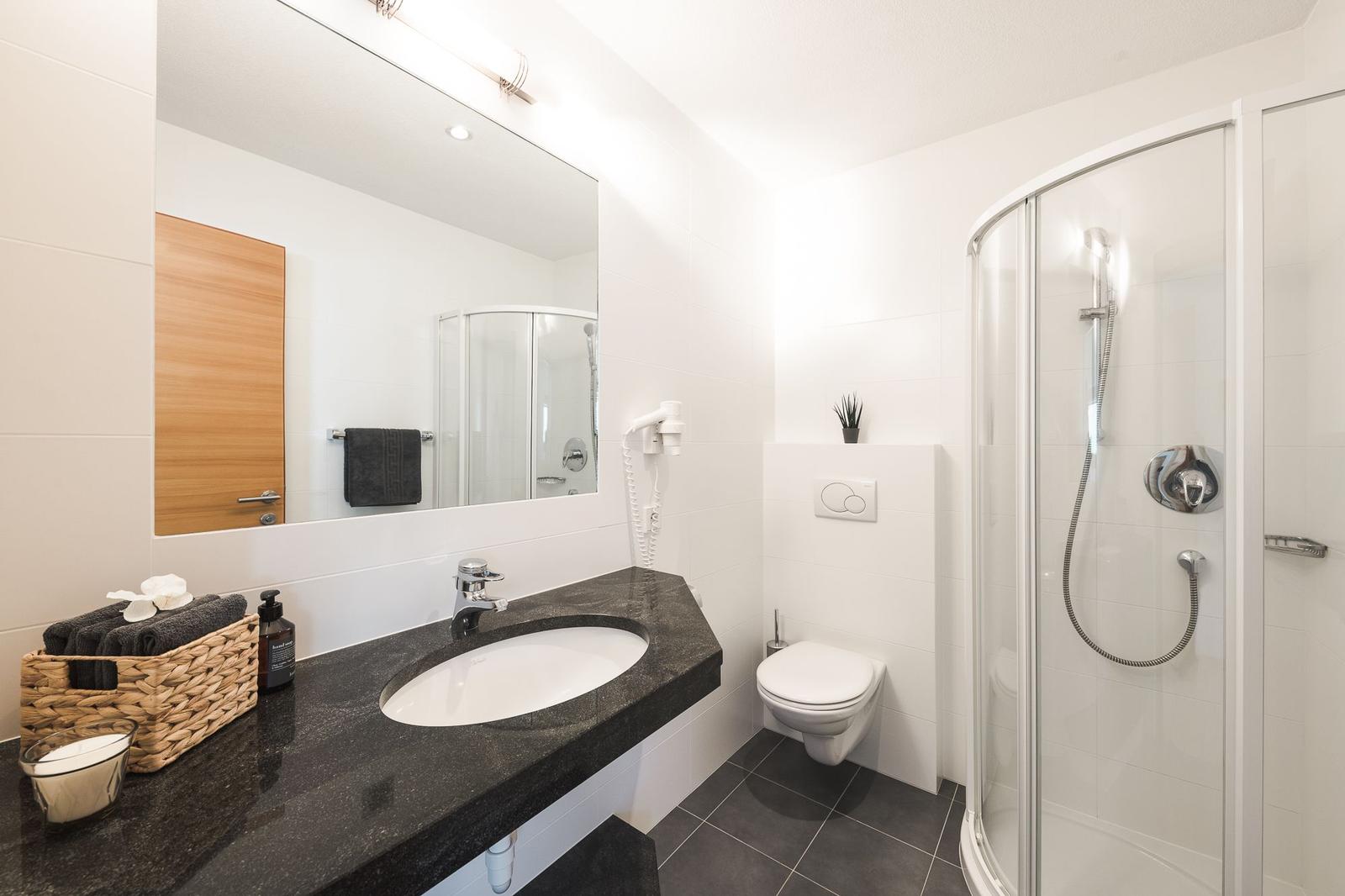 Badezimmer mit Dusche, Waschtisch, WC und Haarfön