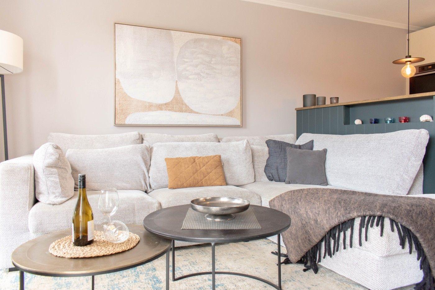 Wohnzimmer mit Sofa, Tischen und Wandbild