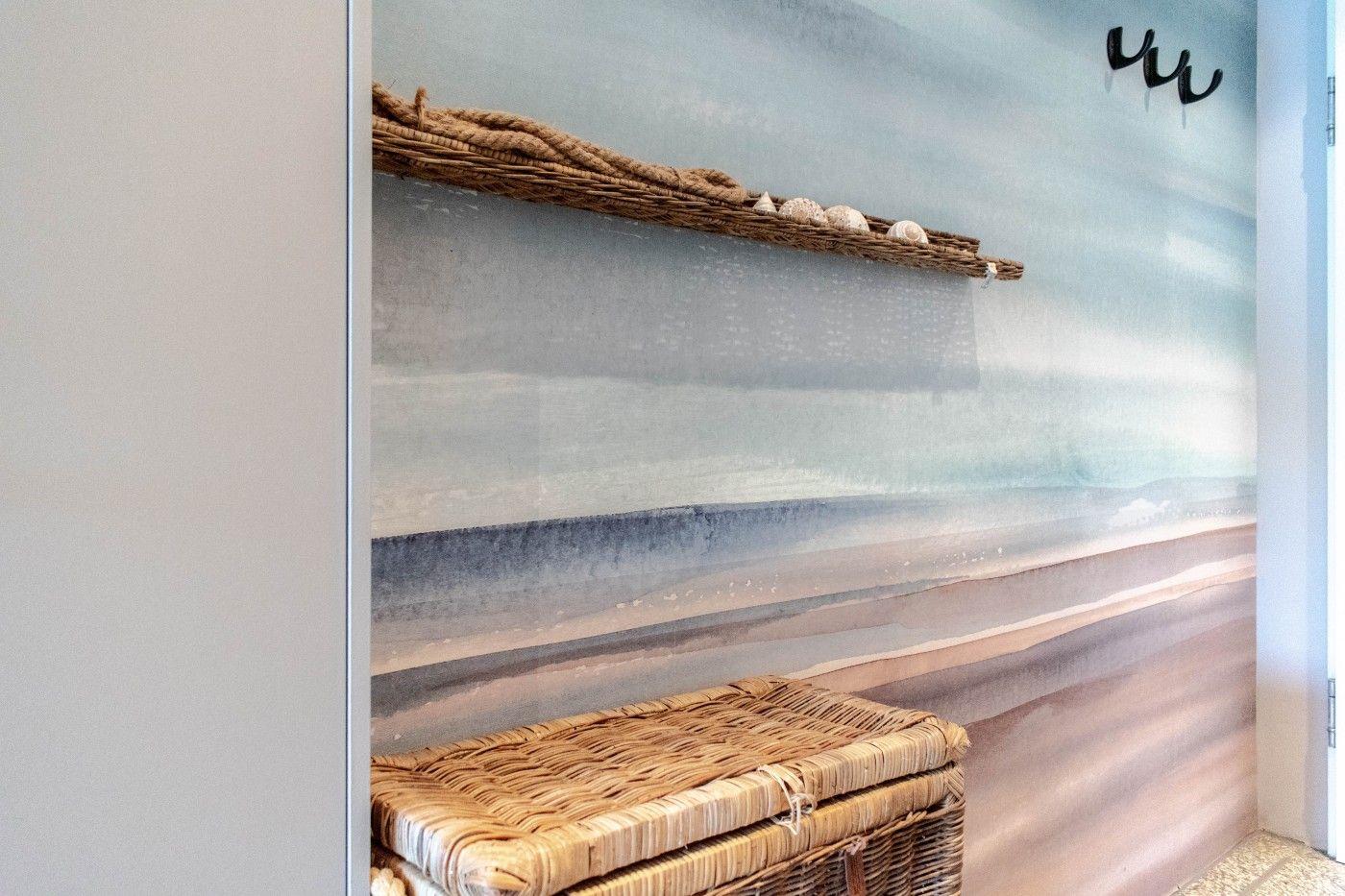 Wand mit Strandmotiv, Korbregal und Korb unten