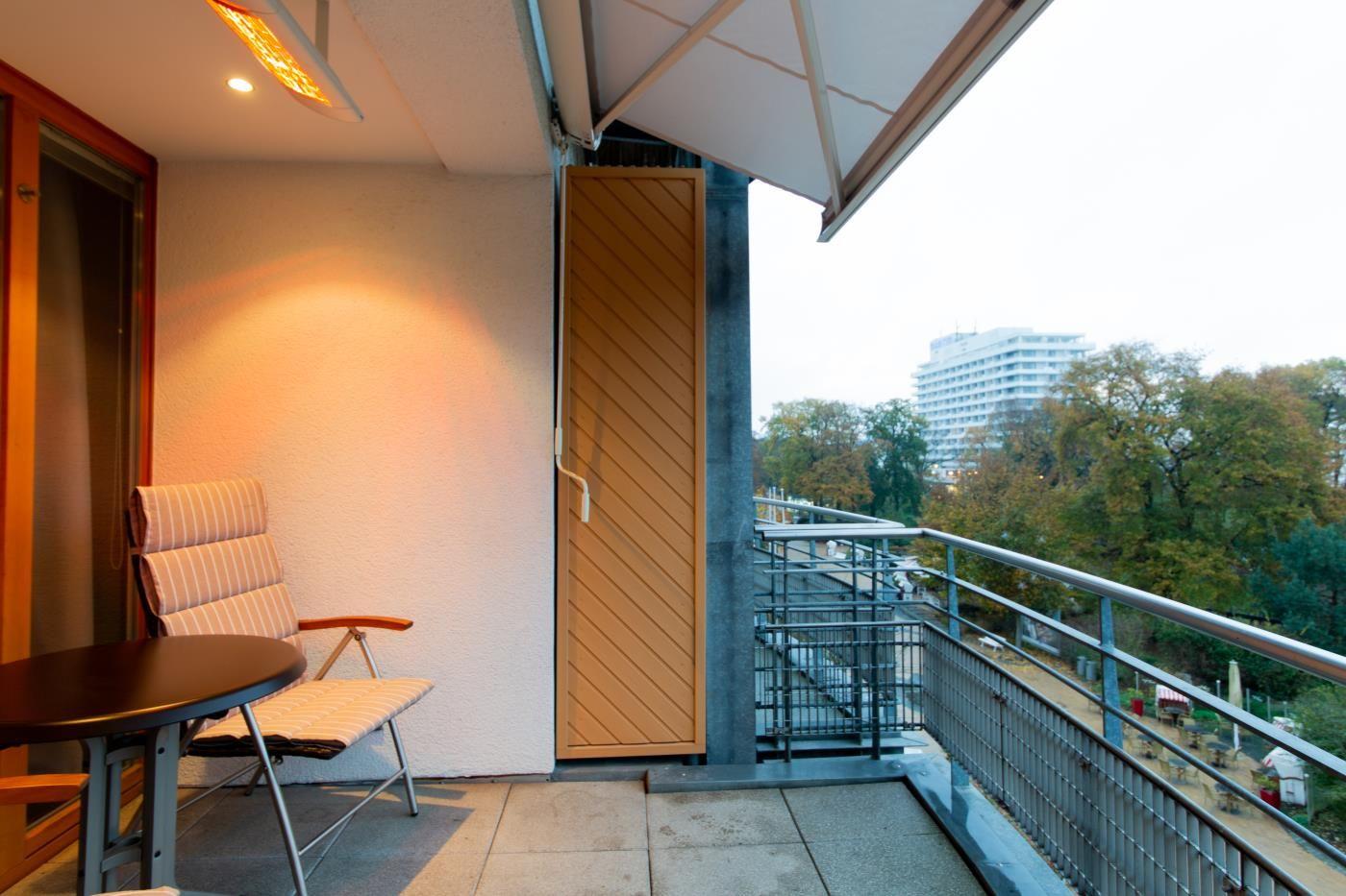 Terrasse mit Sitzgruppe und Blick auf Grünfläche und Gebäude