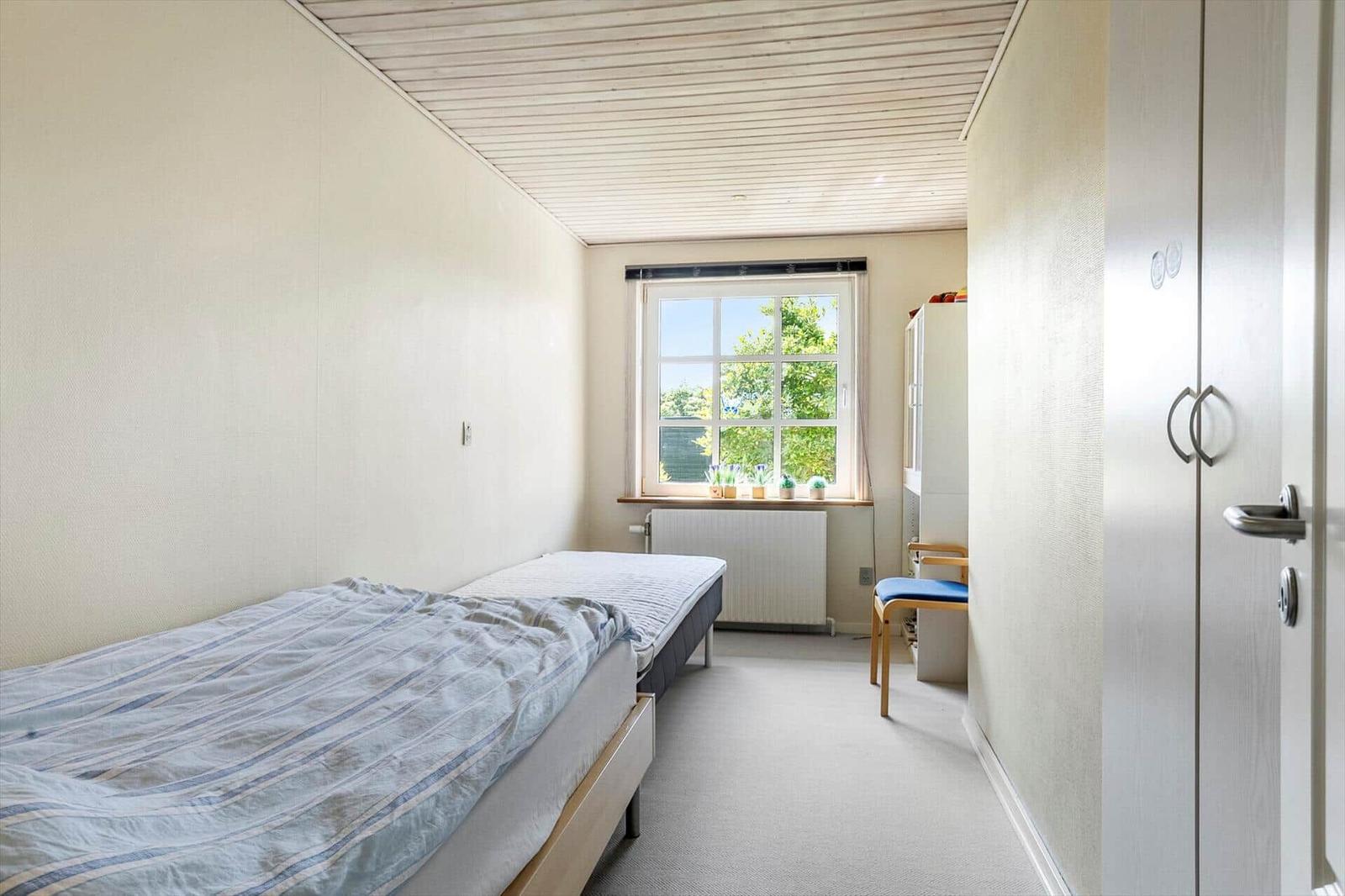 Bedroom with double bed, window, and wardrobe.