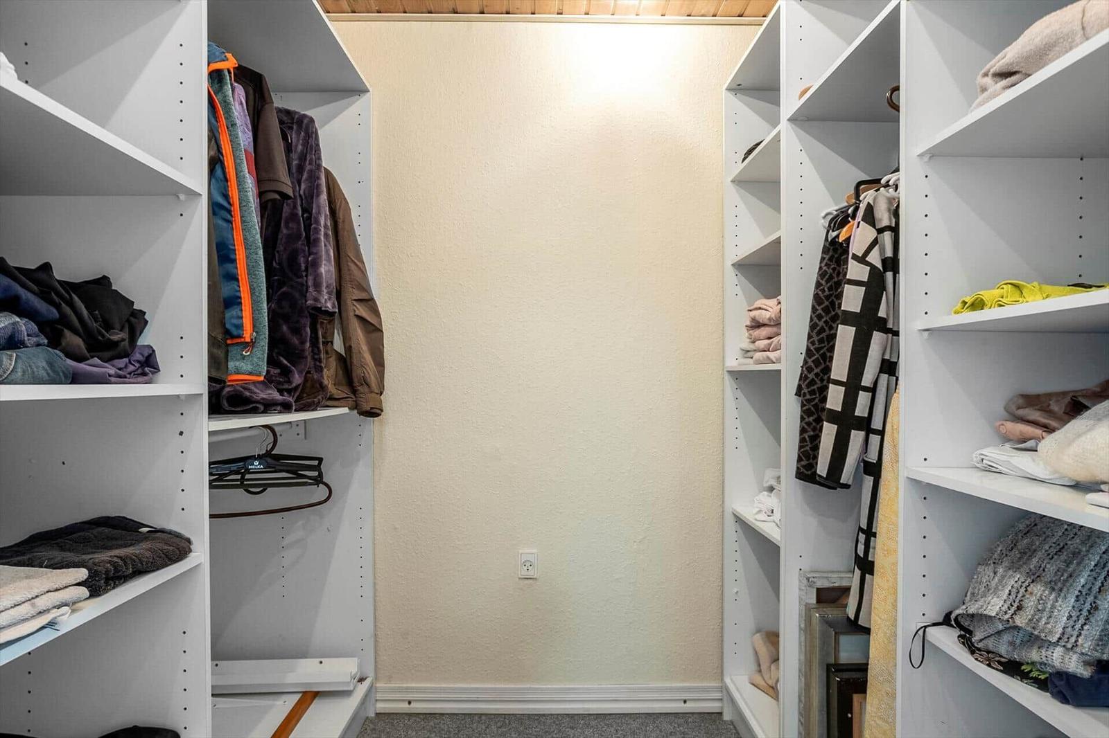 Large closet with multiple shelves and clothing.