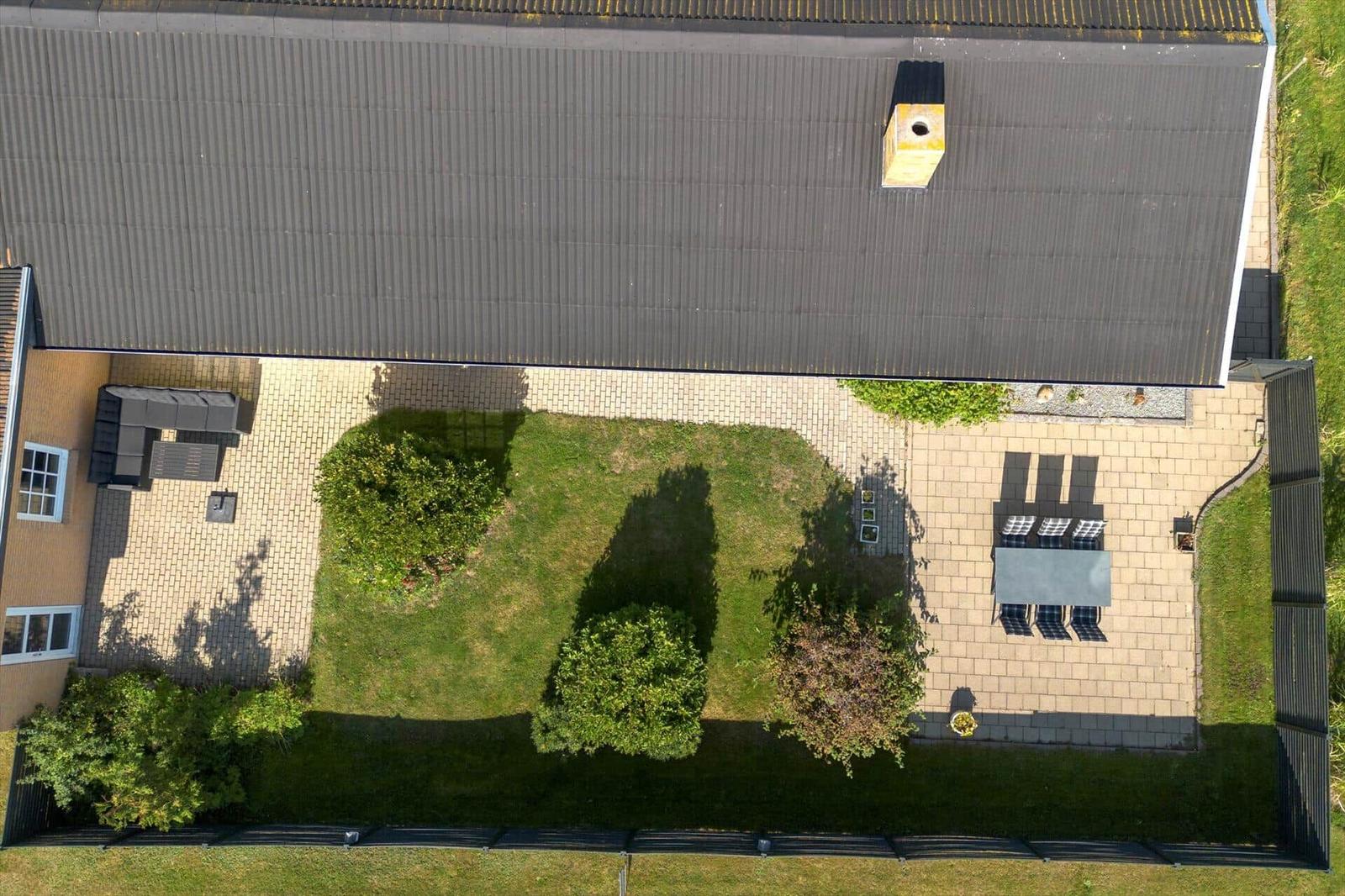 House with garden, terrace, and sunshade. Grilling area and seating.