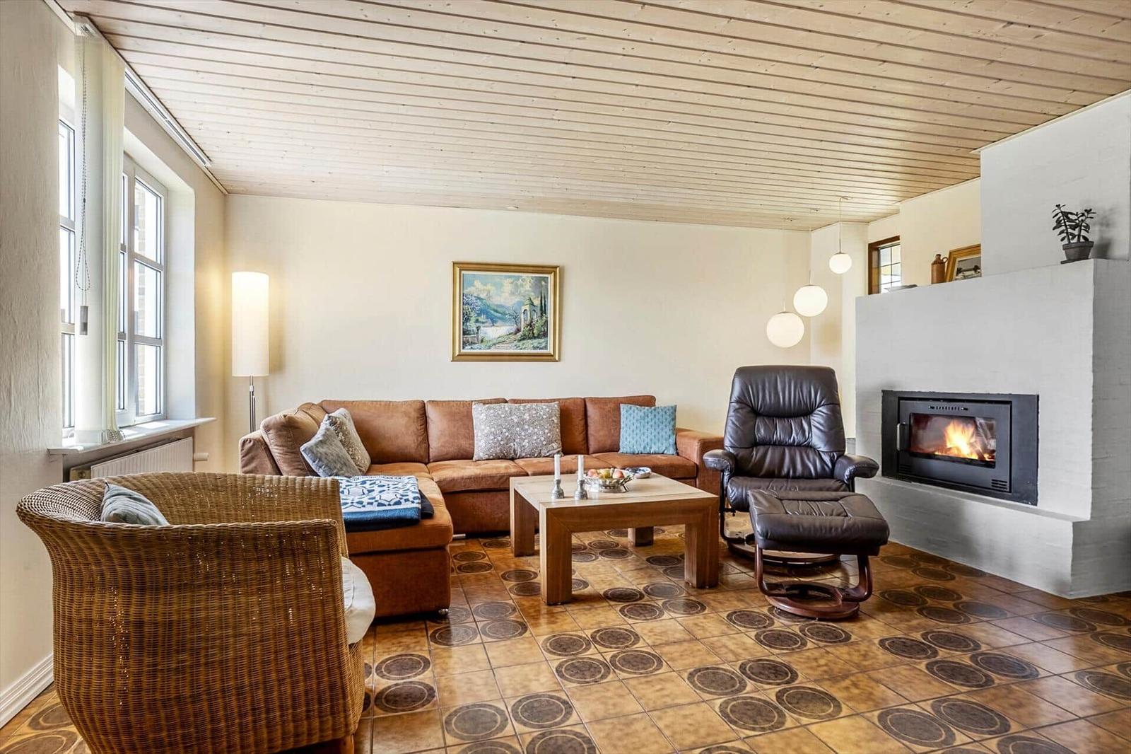 Living room with sofa, armchair, and fireplace