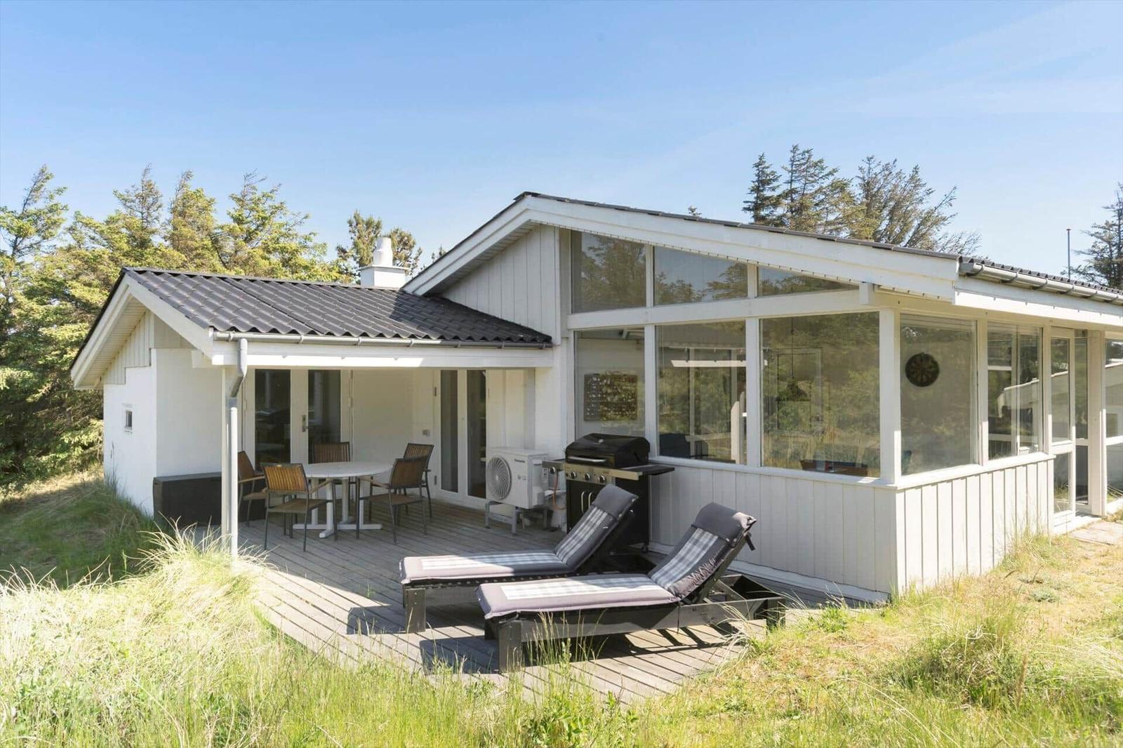 House with terrace, sun loungers, and outdoor grill.